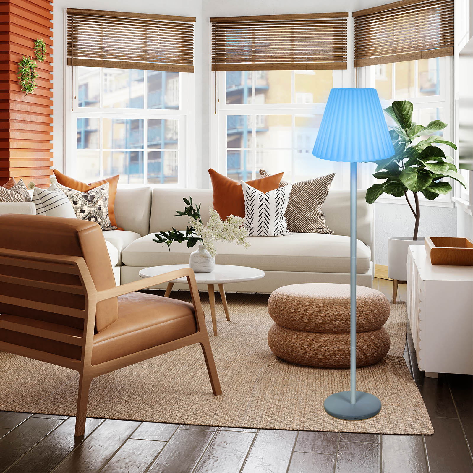 Salon avec canapé blanc, fauteuil marron, lampe bleue et plante. Stores en bois et fenêtres.
