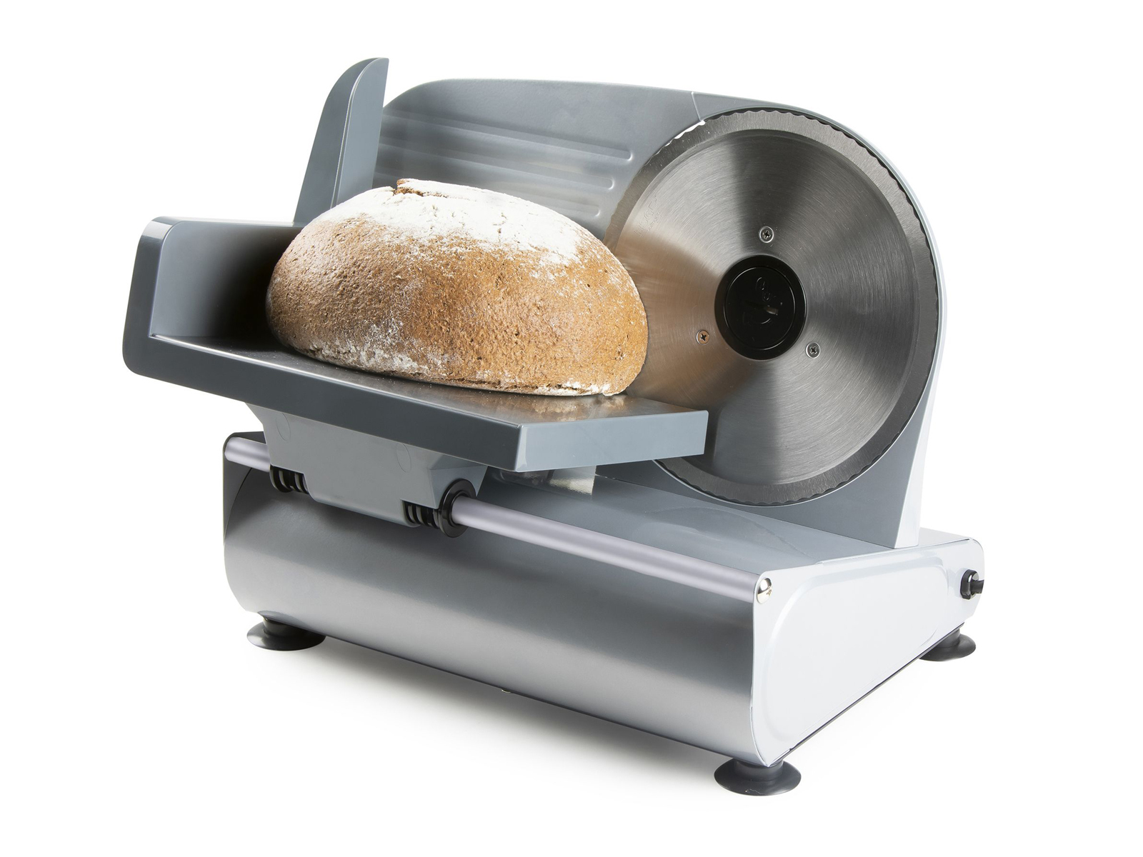 Silberner Brotschneider mit einem Brotlaib auf dem Tablett. Das Brot ist braun.