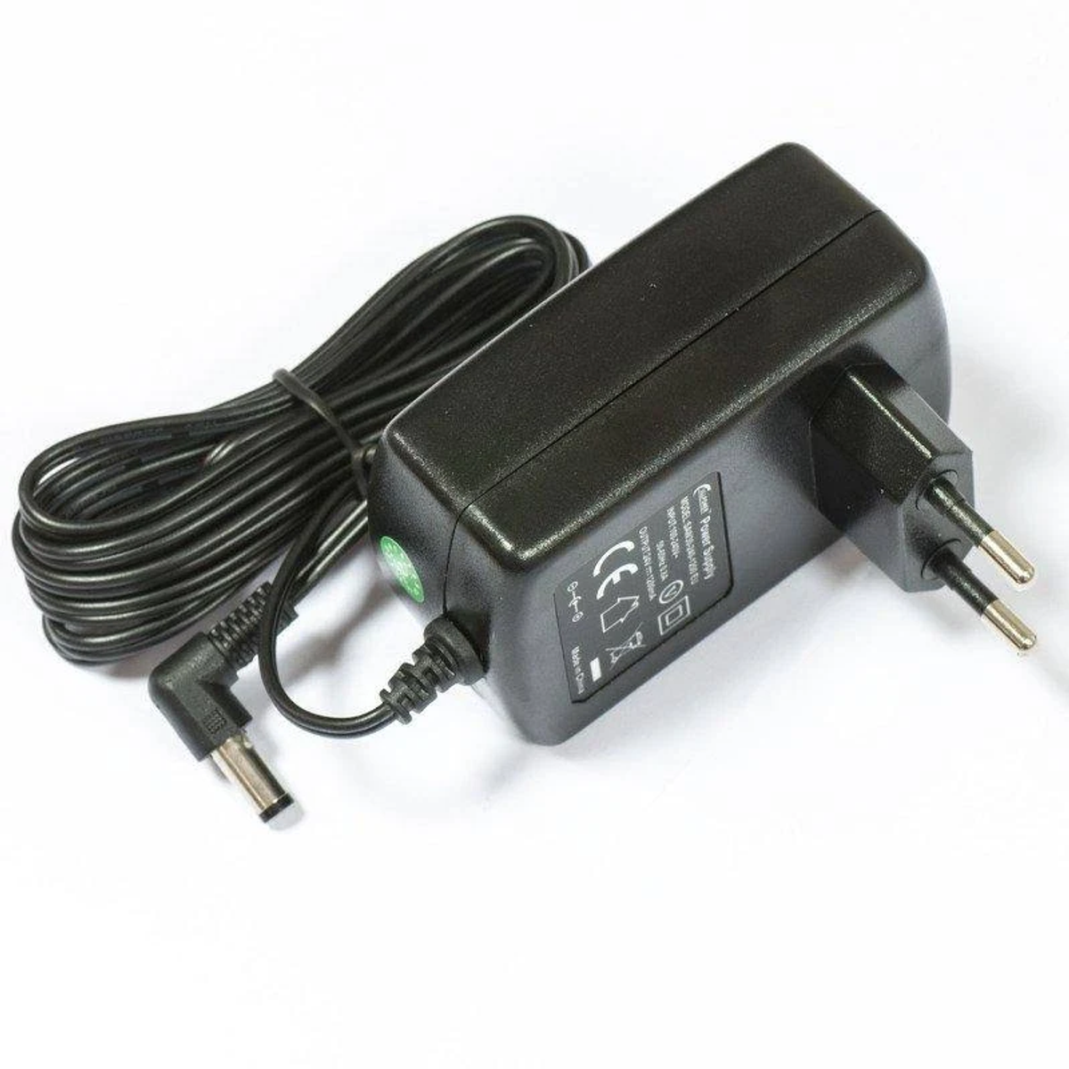 Schwarzes Netzteil mit schwarzem Kabel und zweipoligem Stecker. Weißer Hintergrund.