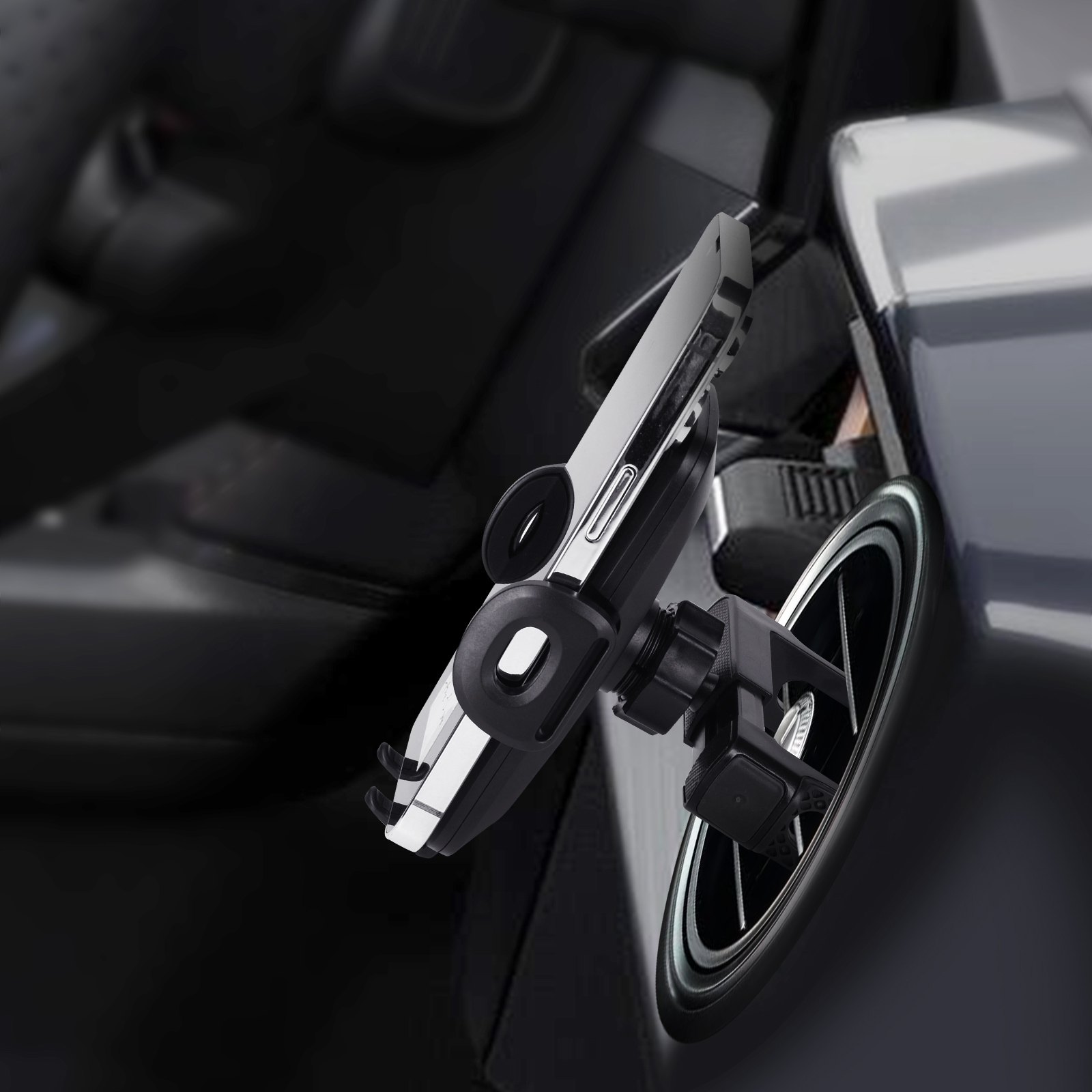 Supporto telefono auto attaccato alla ventola. Telefono nero e argento montato, interno auto visibile.