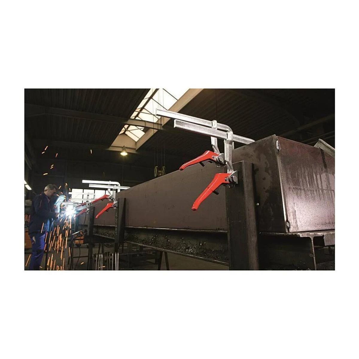Schweißer arbeiten an Metall, Funken fliegen und Klemmen halten die Teile zusammen.