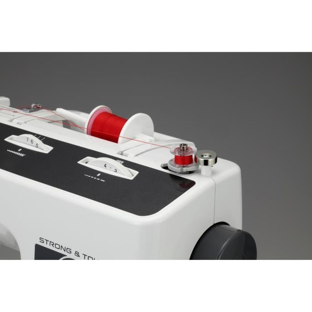 Primer plano del mecanismo de una máquina de coser, con carretes de hilo rojo y piezas blancas.