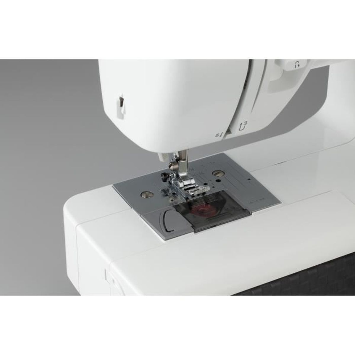 Primer plano de una máquina de coser blanca, enfocando la aguja y el pie.