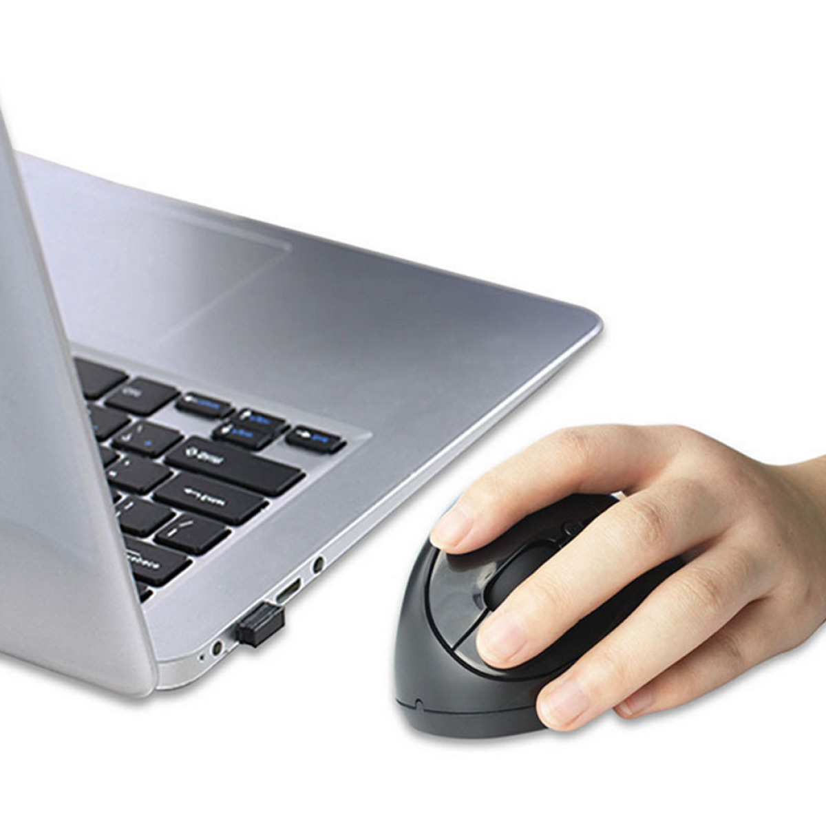 Eine Hand, die eine vertikale ergonomische Maus hält. Ein Laptop ist im Hintergrund sichtbar.