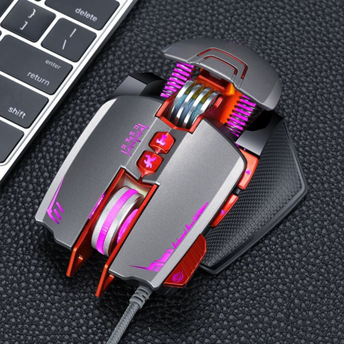 Eine graue und rote Gaming-Maus auf einer schwarzen Oberfläche. Eine Tastatur im Hintergrund.