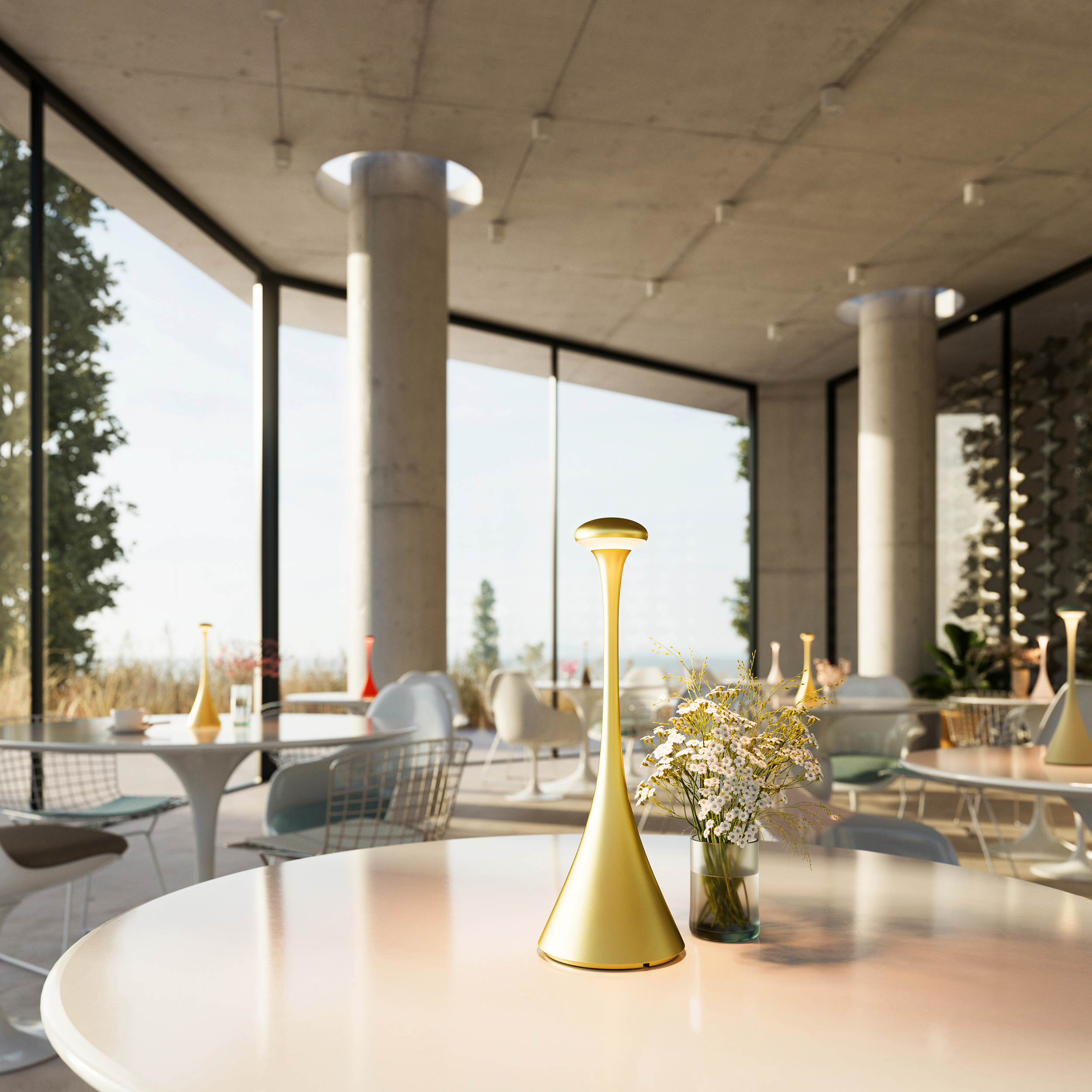 Eine goldene Lampe und Blumen stehen auf einem Tisch in einem modernen Restaurant mit großen Fenstern.