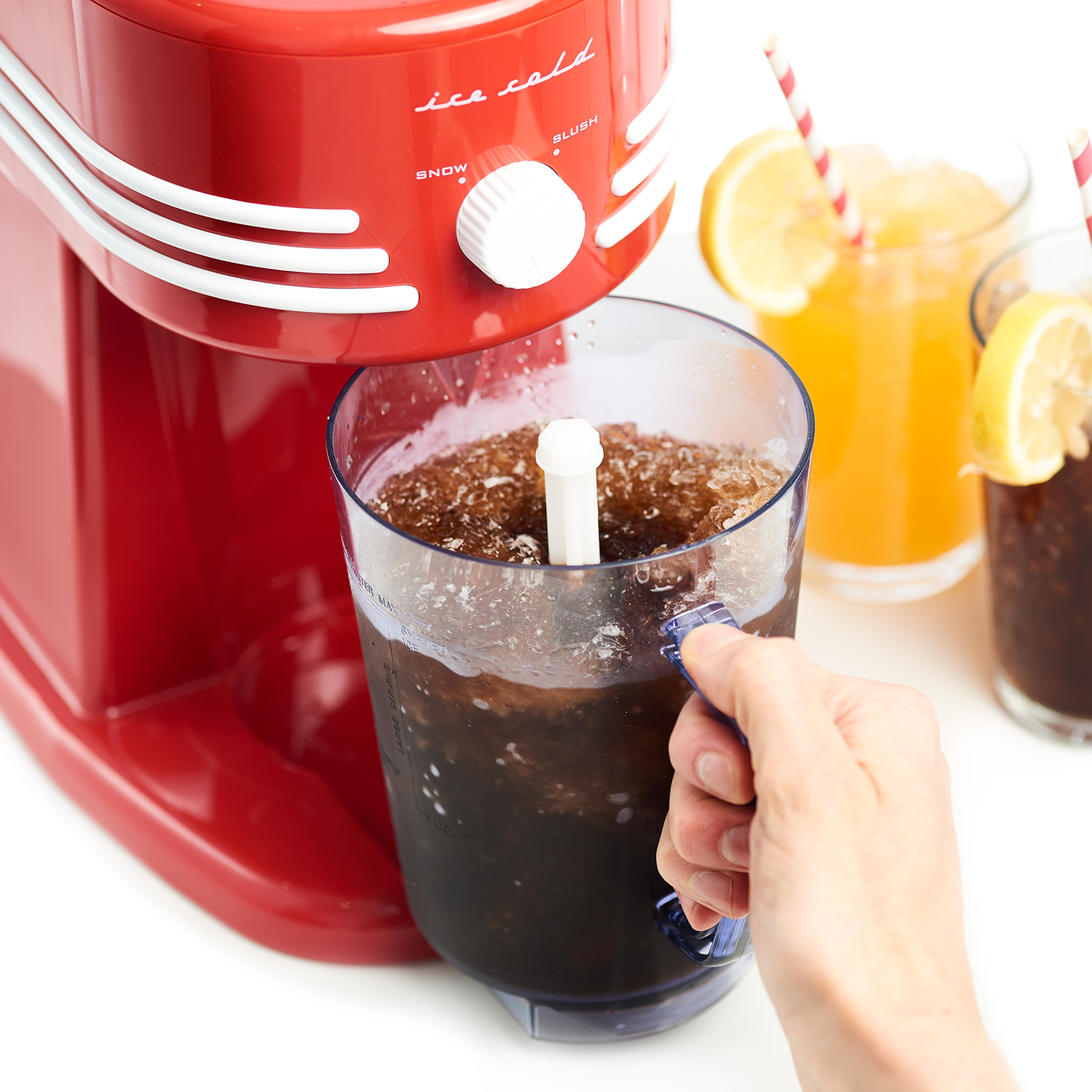 Eine rote, eiskalte Slush-Maschine mit blauem Griff, die einen Drink ausgießt. Zwei weitere Getränke rechts.