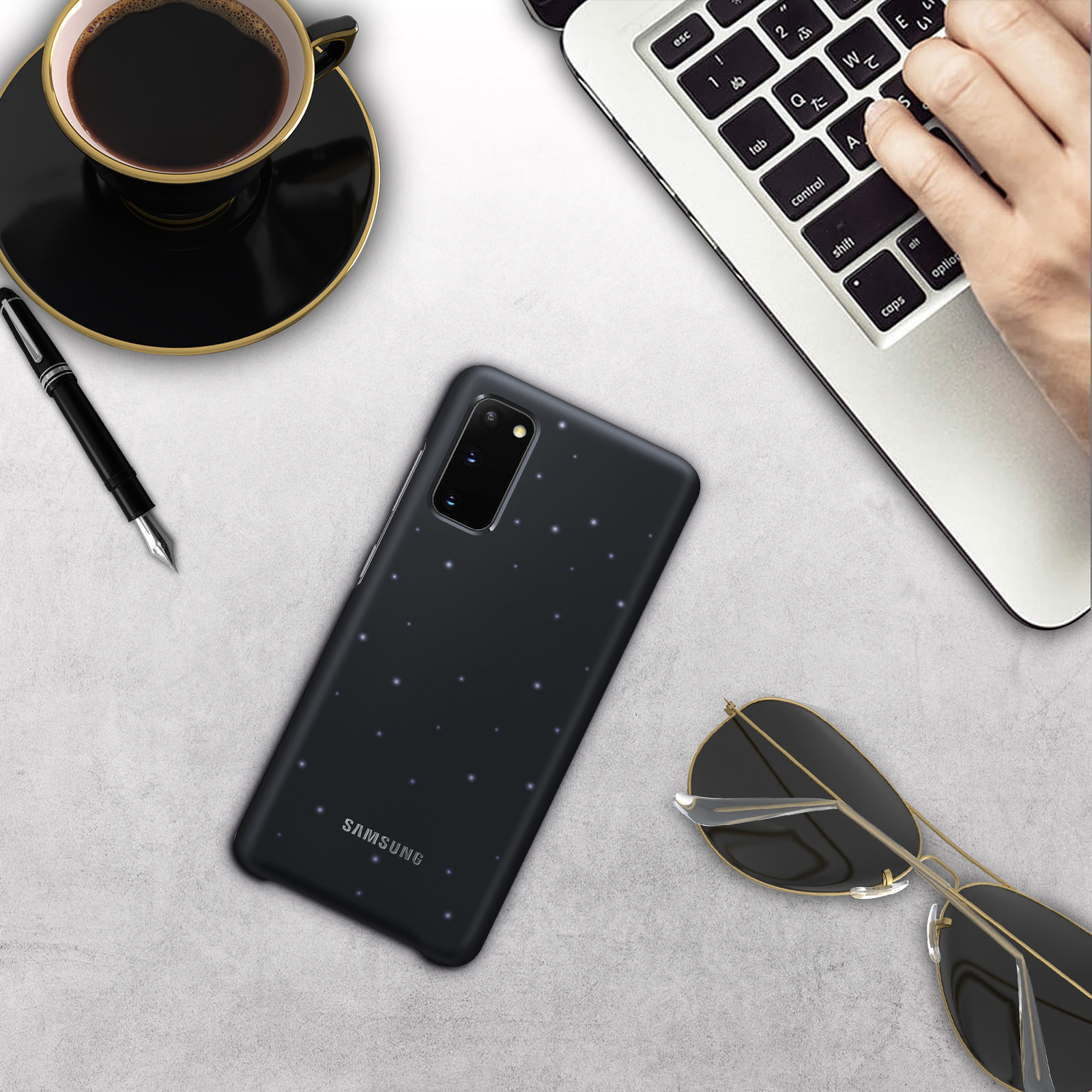 Ein Telefon mit Hülle und andere Gegenstände auf einem Tisch. Das Telefon hat eine schwarze Hülle.