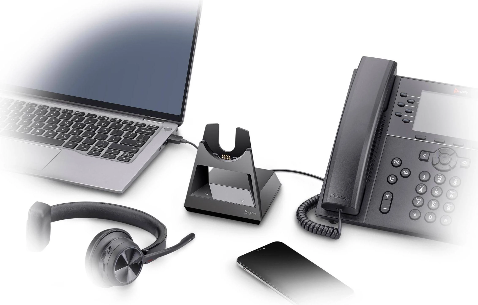 Büro-Setup mit Laptop, Headset, Telefon, Smartphone und einer Ladestation, die mit allem verbunden ist.
