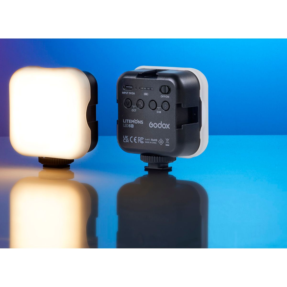 Zwei weiße und schwarze Lichter mit Knöpfen und Beschriftungen. Blauer Hintergrund.