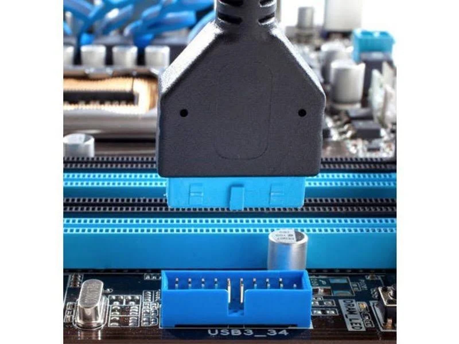 Close-up of a USB 3.0 connector plugged into a motherboard. Blue connector and port are visible.