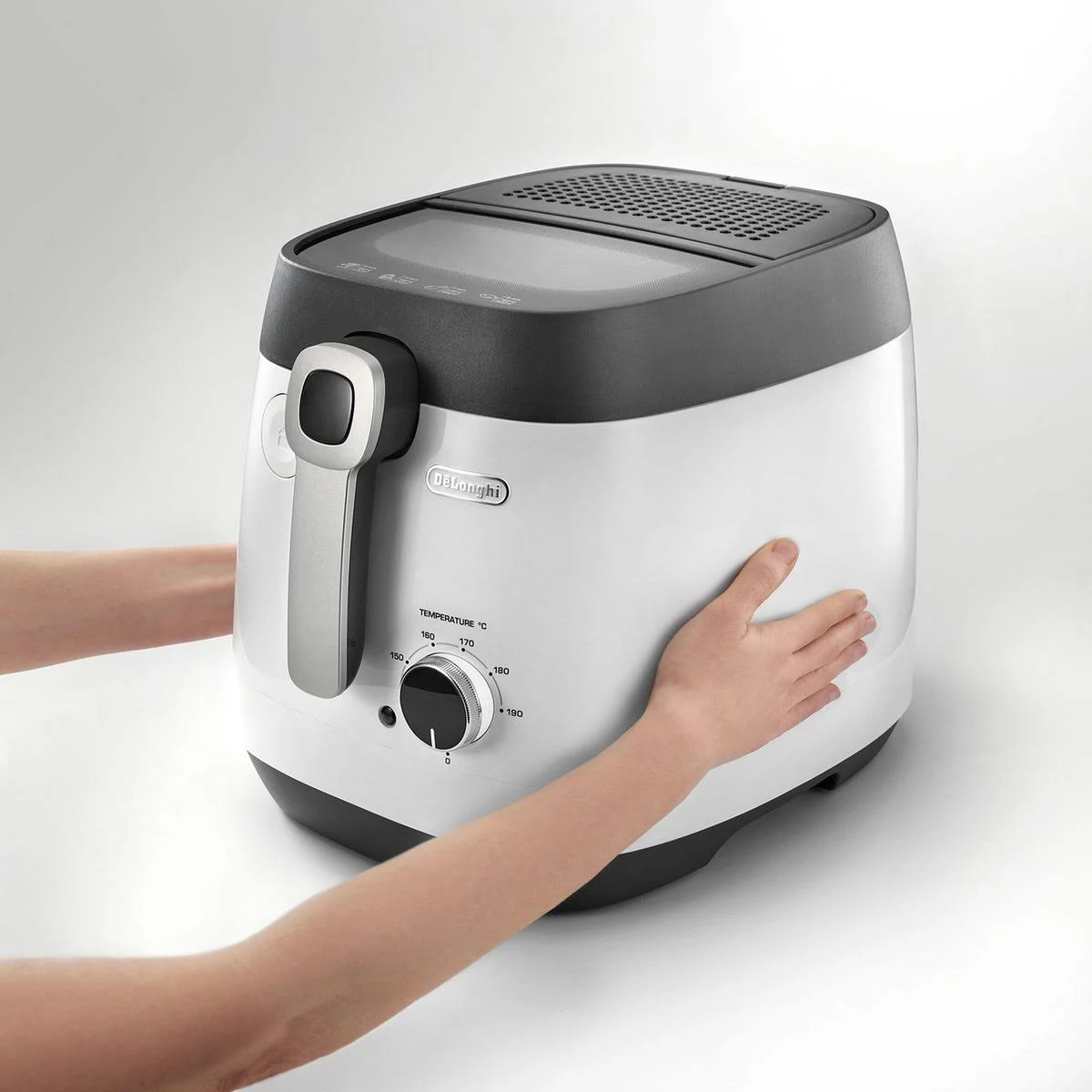 Biało-czarna frytkownica z uchwytem, trzymana przez dwie ręce.