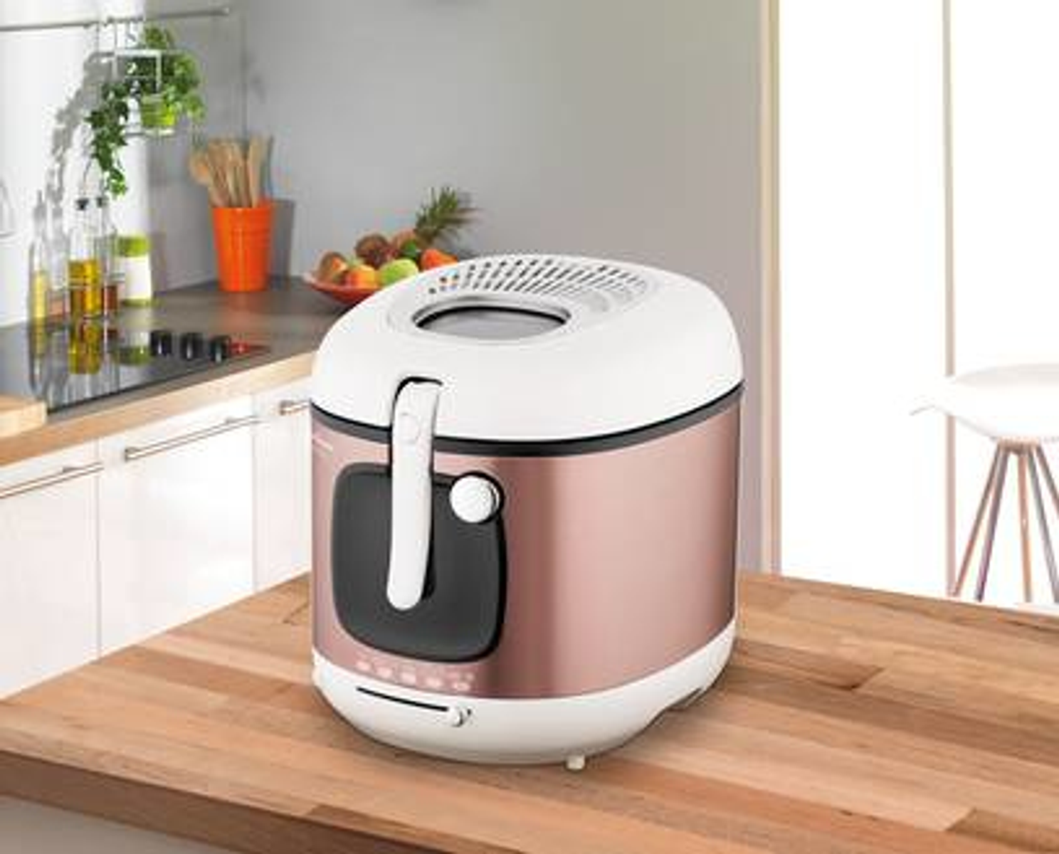 Biała i różowo-złota frytkownica na drewnianym blacie w kuchni.