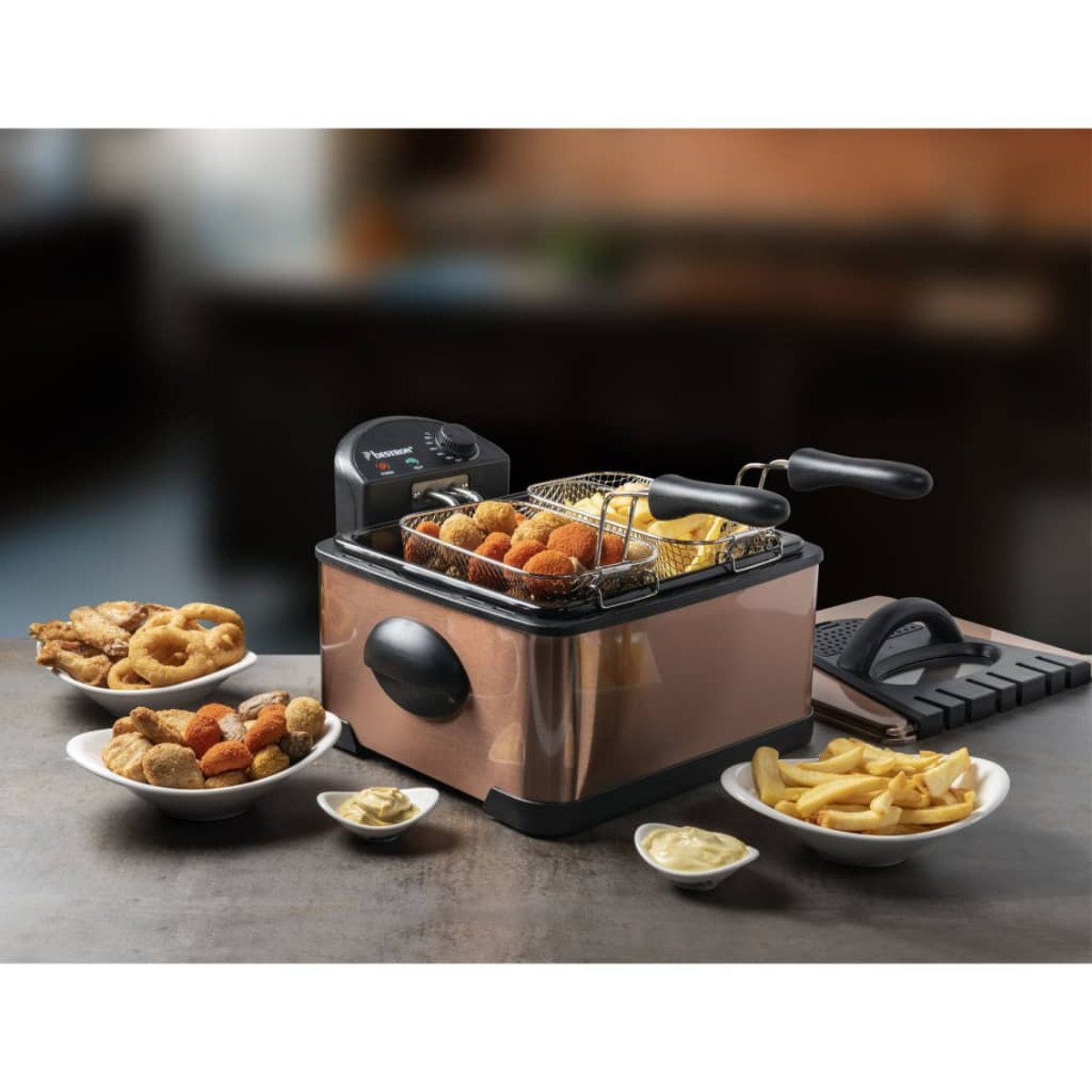 Friggitrice con cibo fritto. Include pollo fritto, patatine fritte e anelli di cipolla.