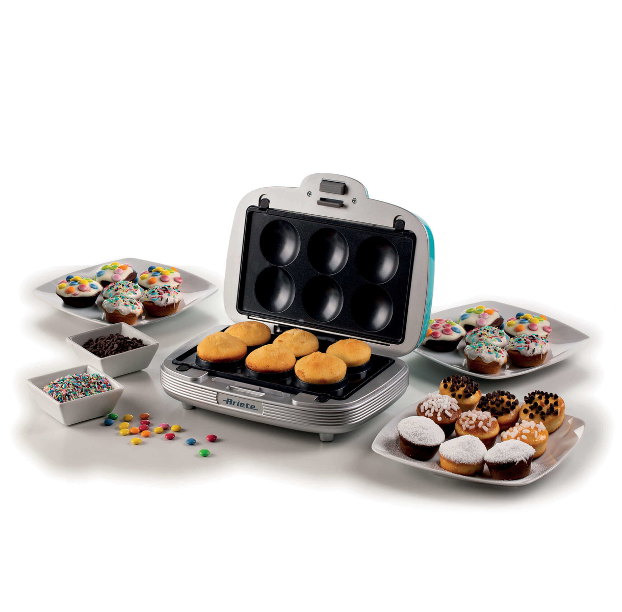 Maszyna do robienia pączków z pączkami i dodatkami na talerzach i w małych miseczkach.