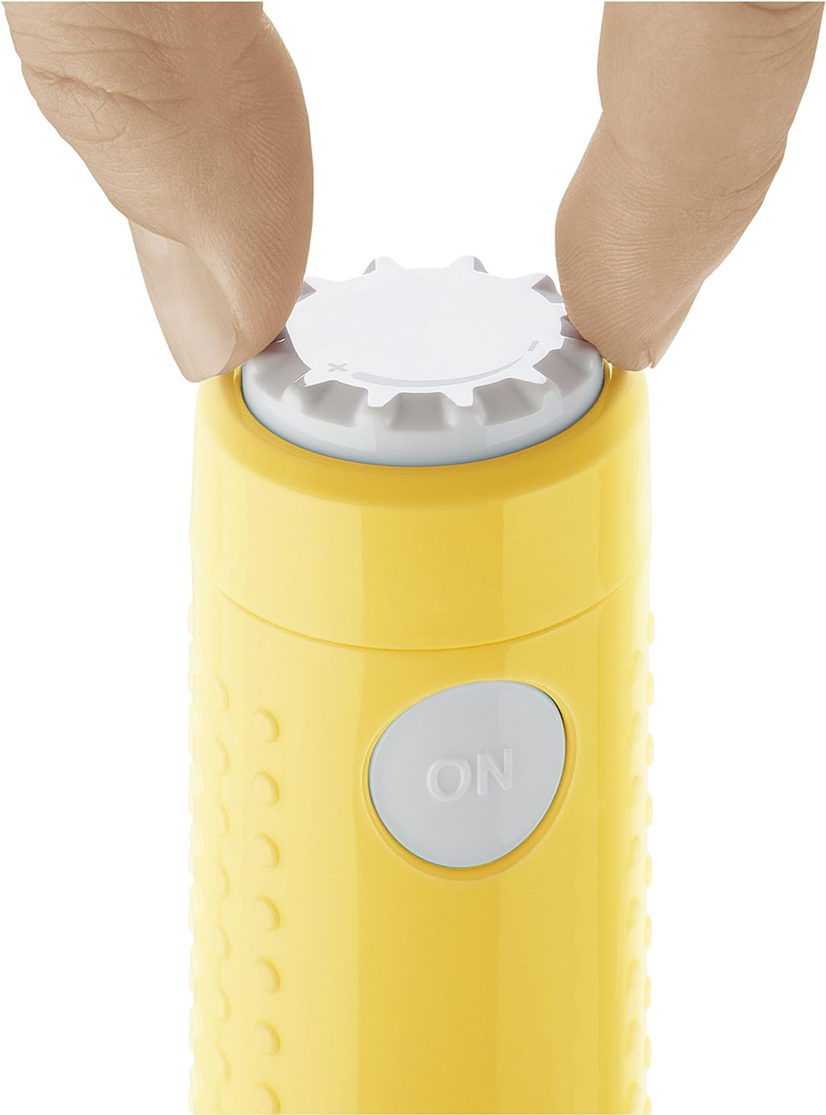 Primo piano di un dispositivo elettrico giallo con pulsante bianco, mani azionano il quadrante superiore.