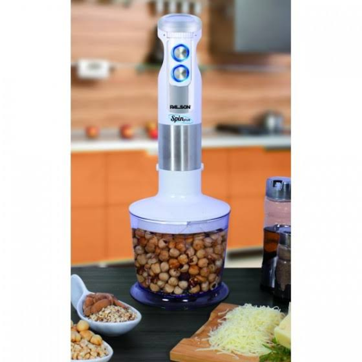 Una batidora de mano blanca y plateada mezcla garbanzos en un recipiente.