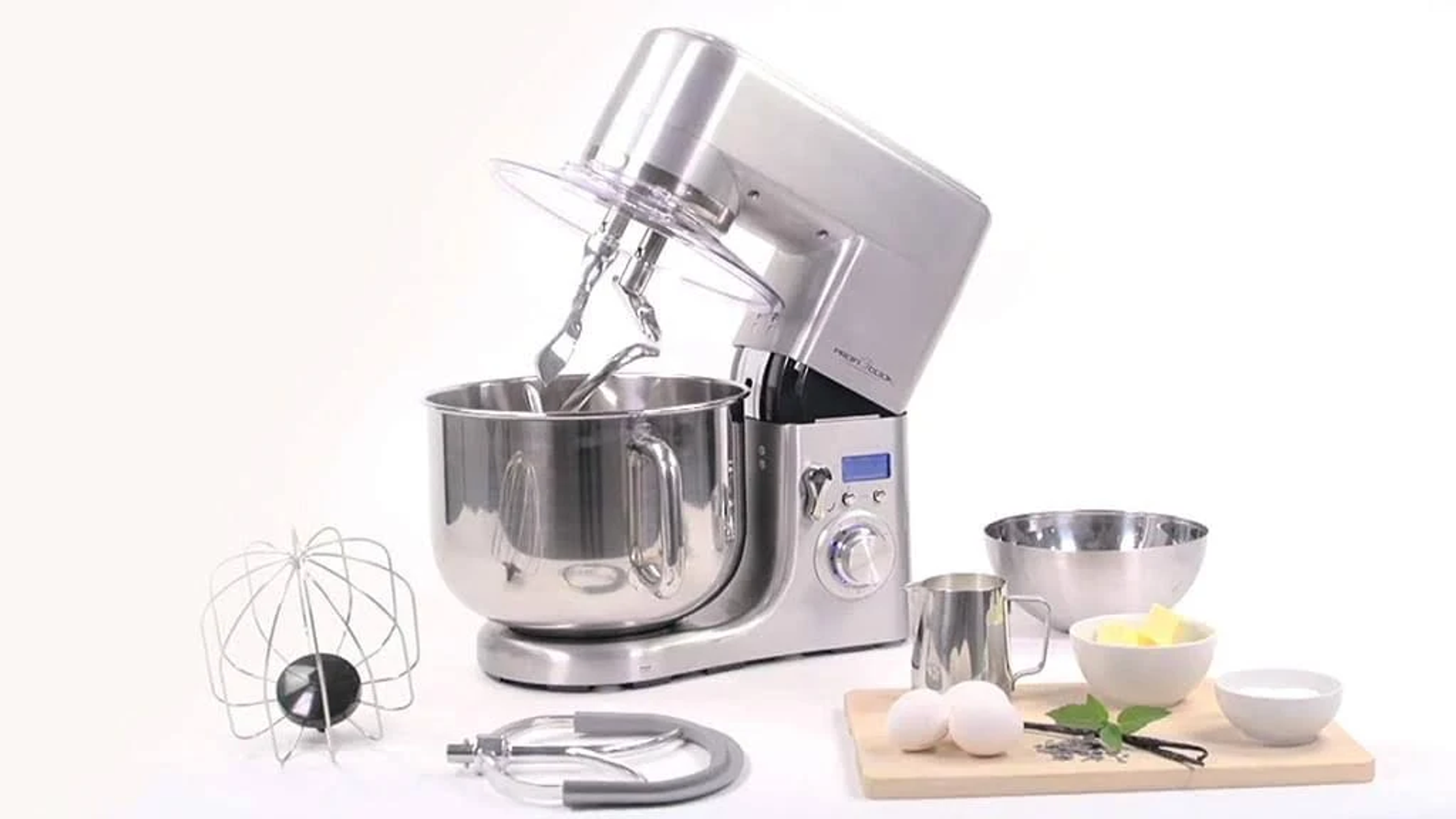 Impastatrice in argento e acciaio con accessori e ciotole, con ingredienti pronti.