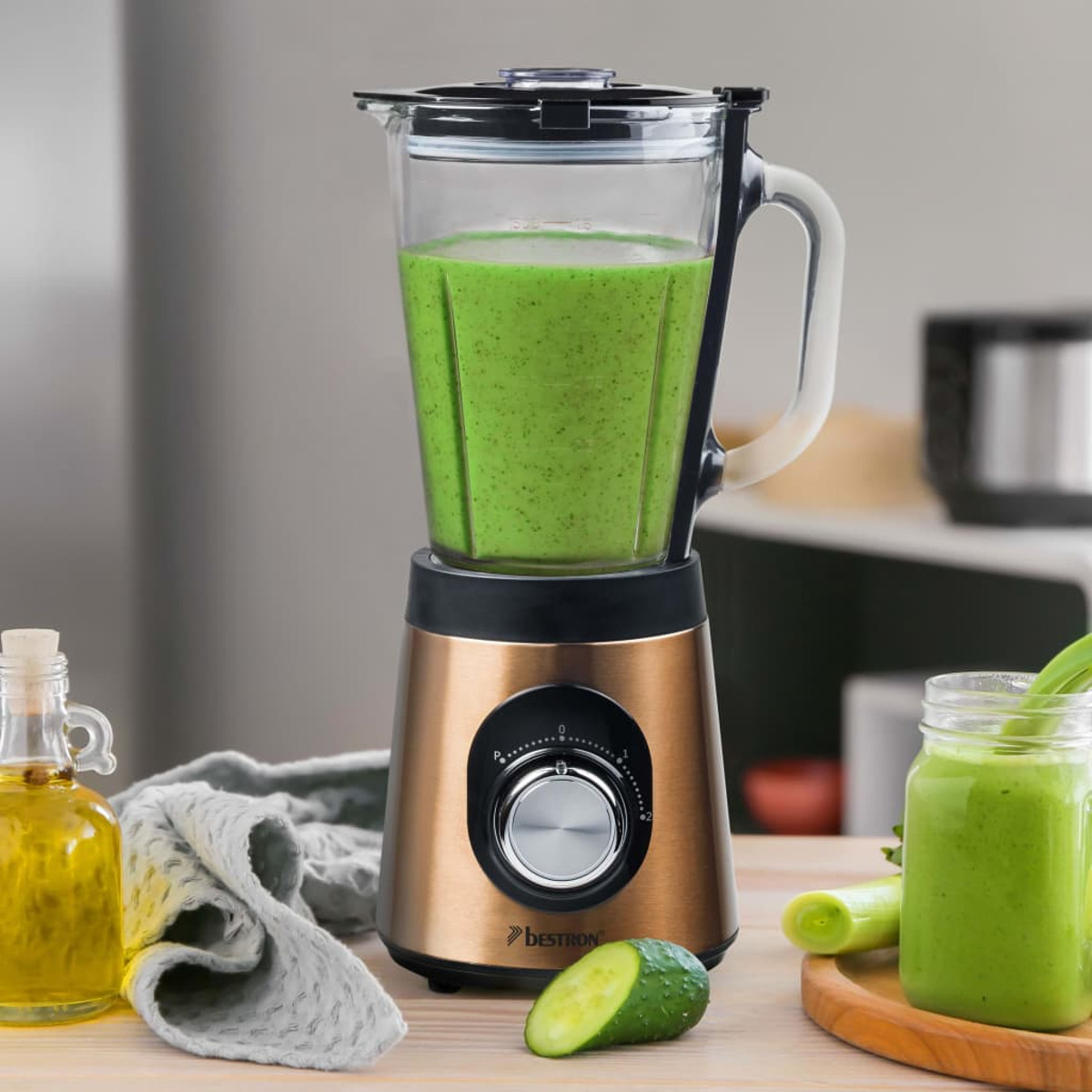 Frullatore con frullato verde. Vasetto di frullato e ingredienti sullo sfondo. Tavolo di legno.
