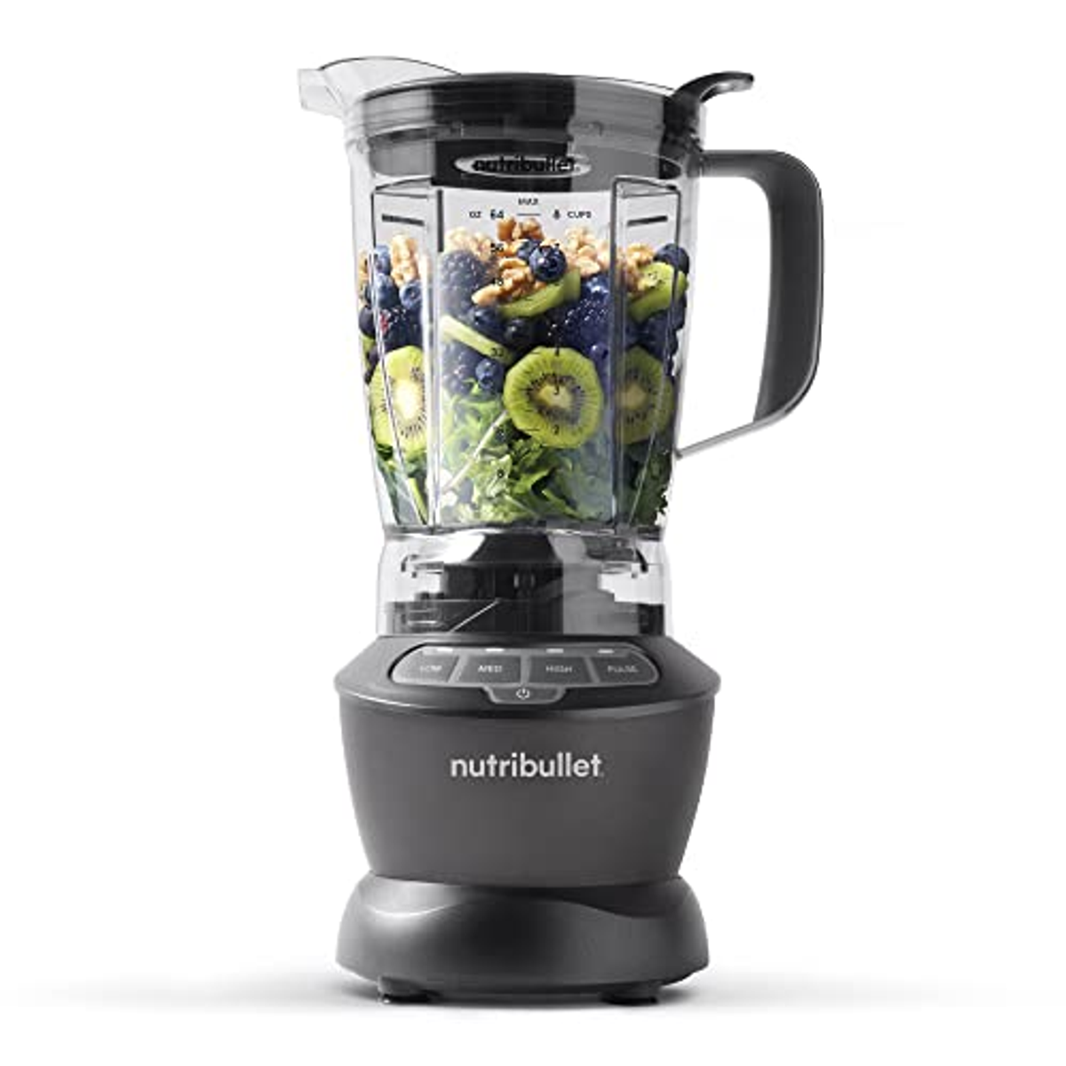 Una licuadora Nutribullet con base negra, un recipiente transparente lleno de frutas y nueces, sobre blanco.