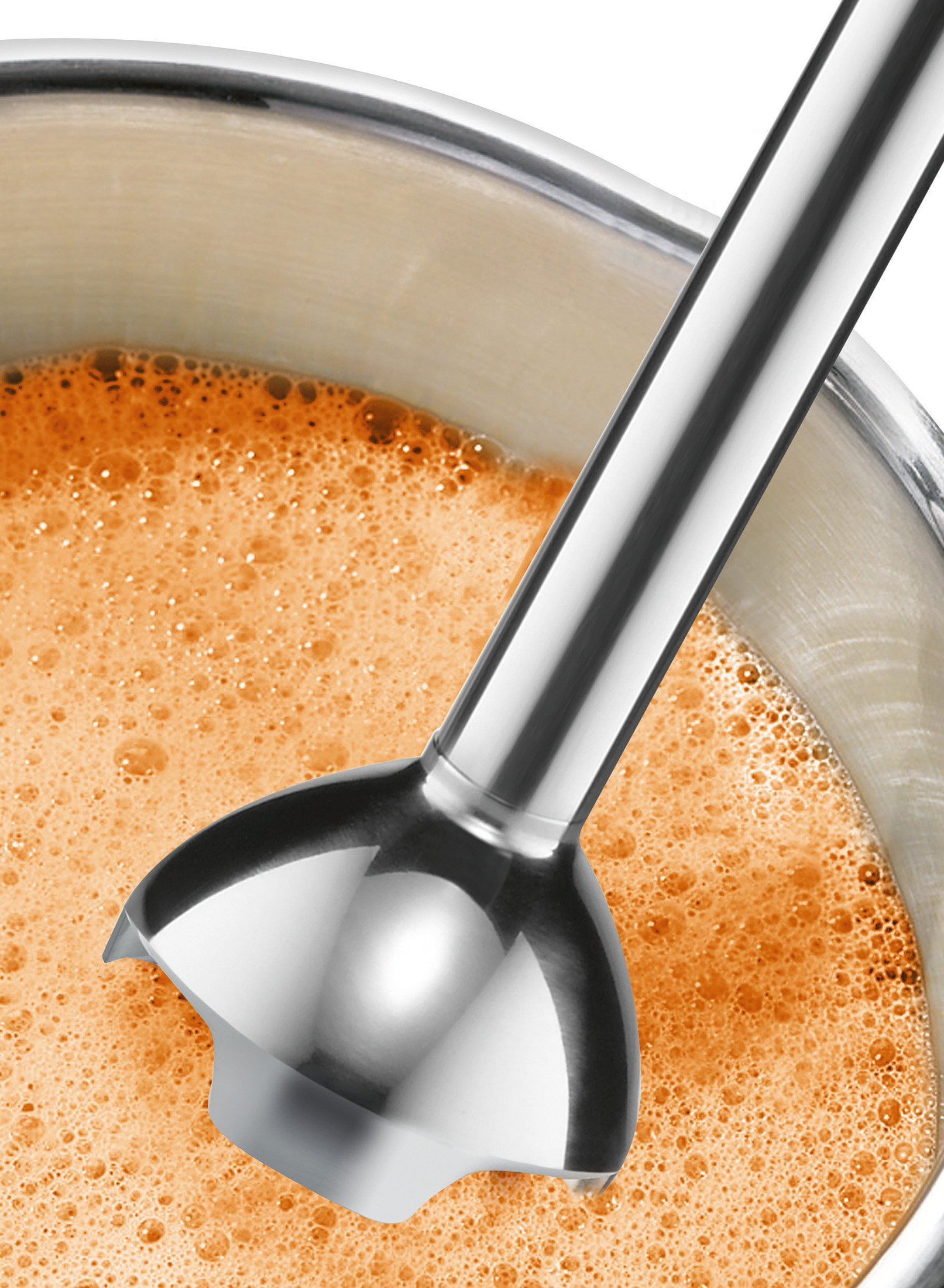 Srebrny blender zanurzeniowy jest w misce z pomarańczowym płynem z bąbelkami.