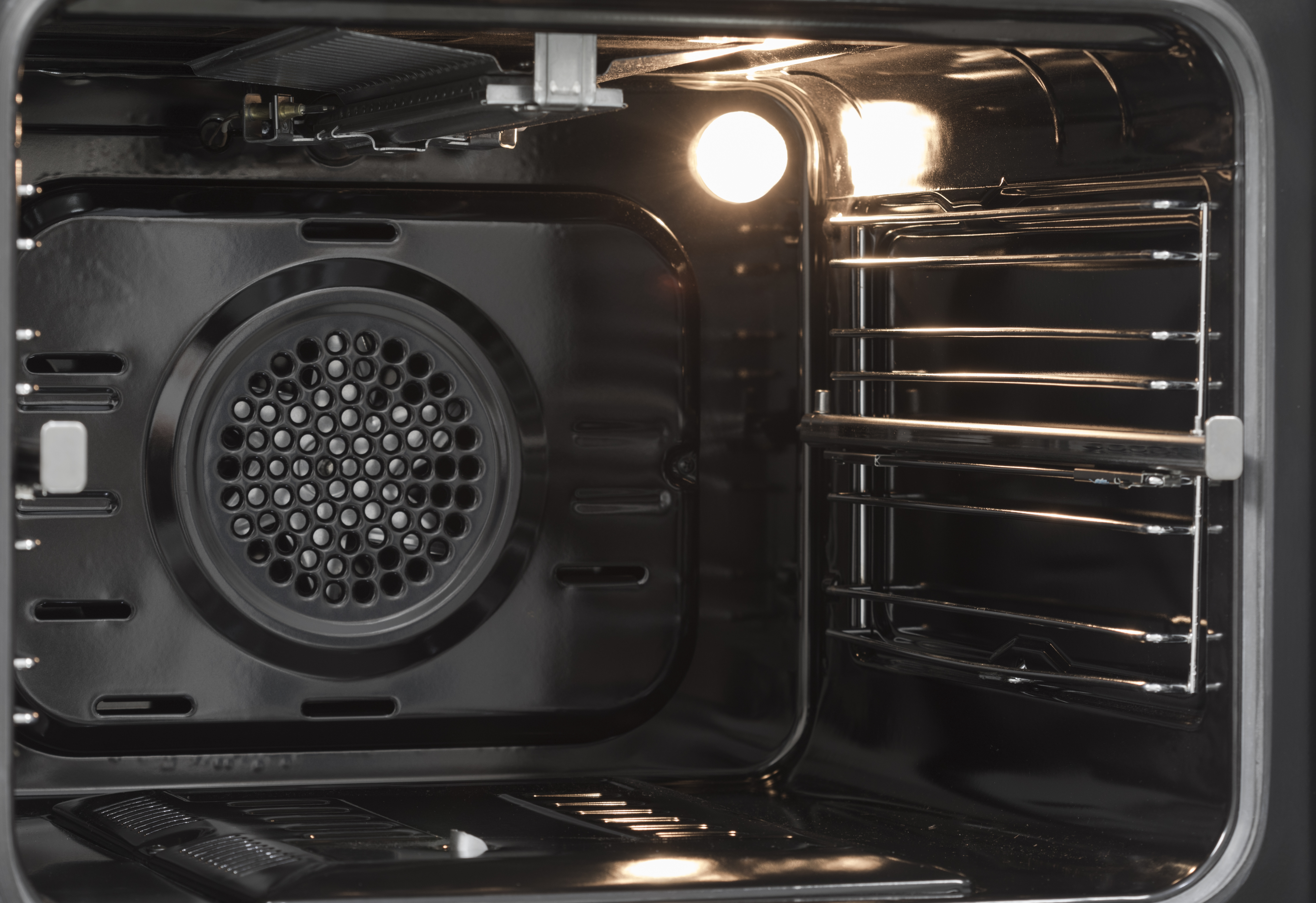 Dentro de un horno iluminado. Cuenta con ventilador y rejillas.