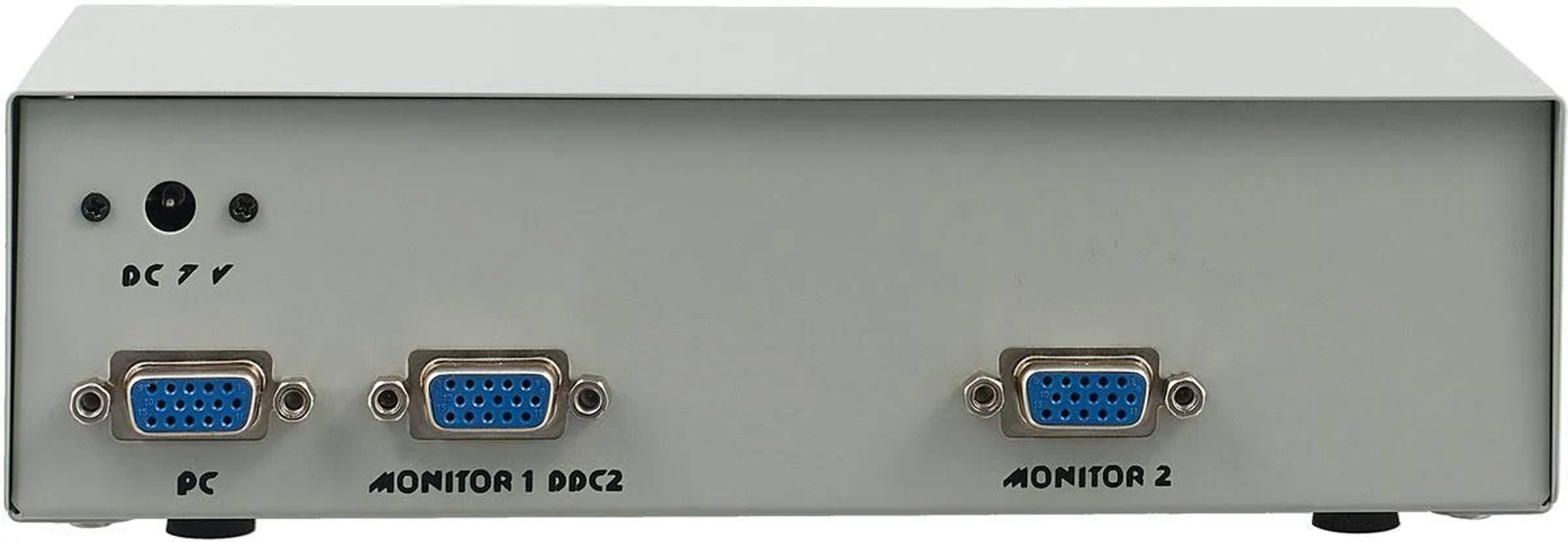 Vista trasera de una caja gris con conectores. Contiene puertos PC, Monitor 1 y Monitor 2.
