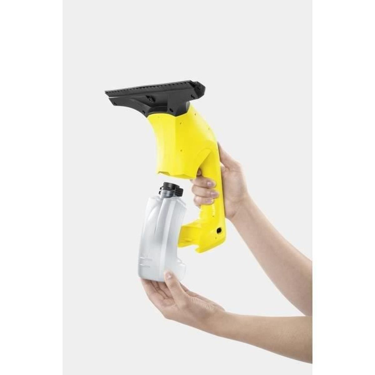 Pulitore per vetri giallo tenuto in mano. Si sta attaccando un contenitore bianco.