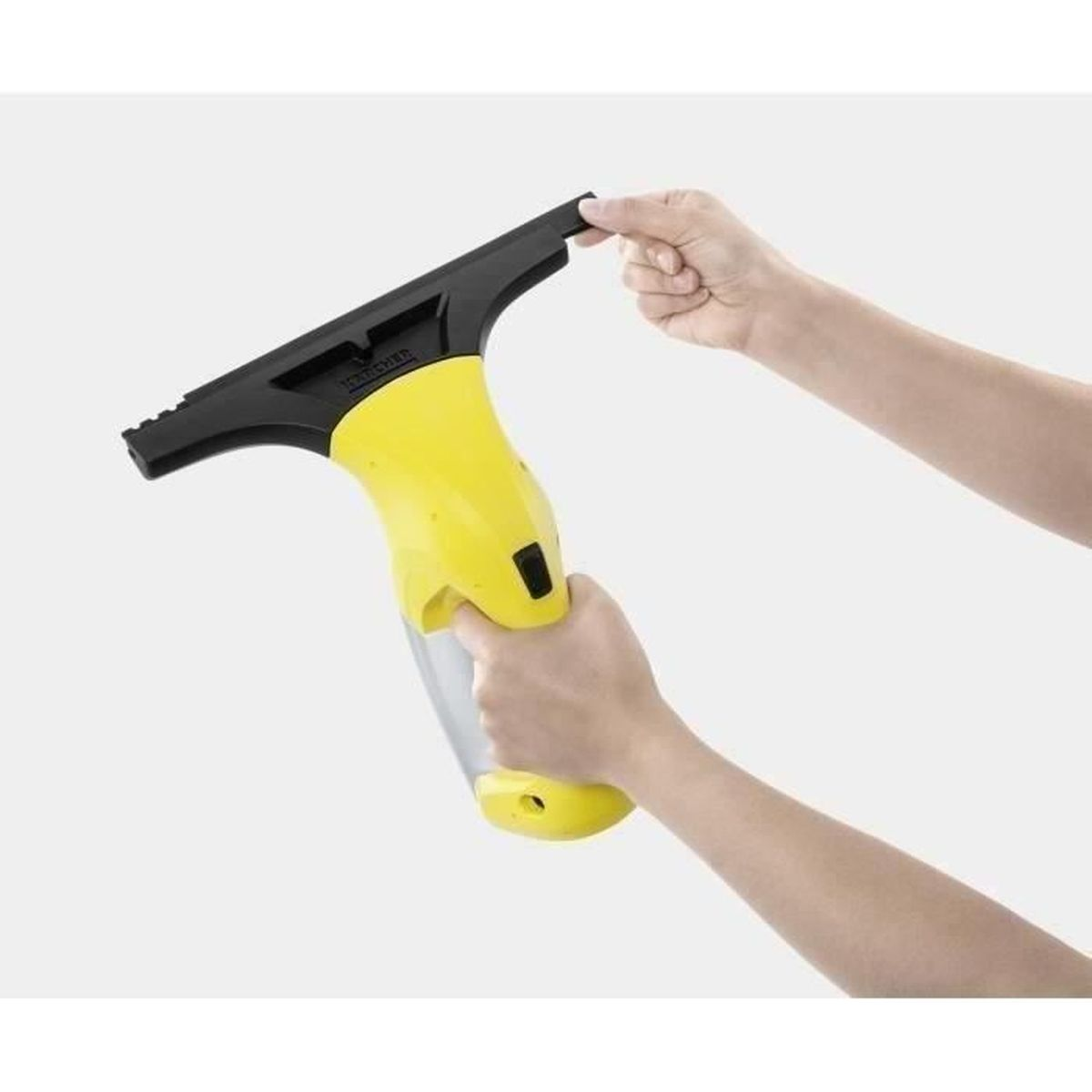 Una persona tiene in mano un pulisci vetri giallo e nero con entrambe le mani. Il pulitore è angolato.