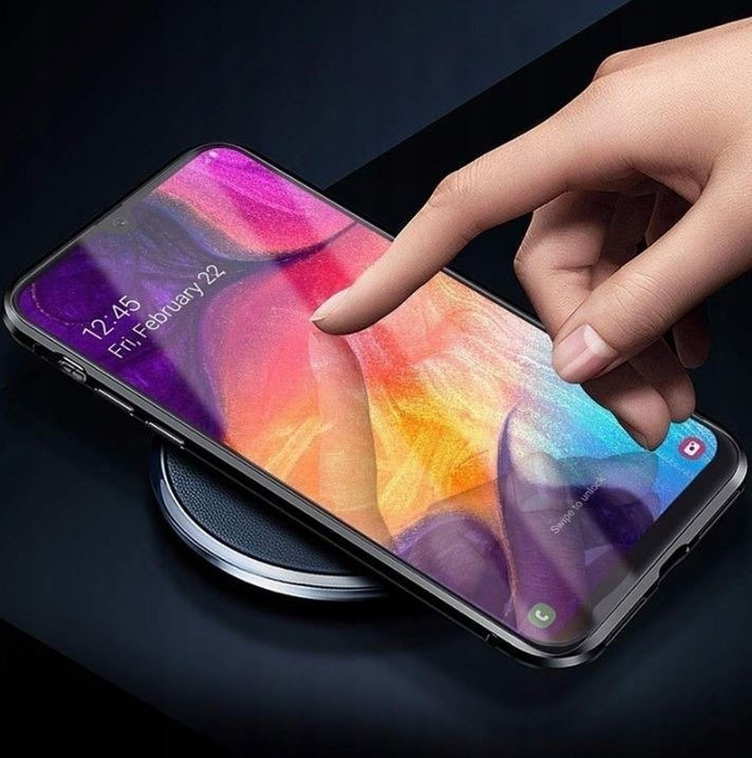 Mano che tocca un telefono su un caricatore wireless. Lo schermo del telefono mostra un calendario.