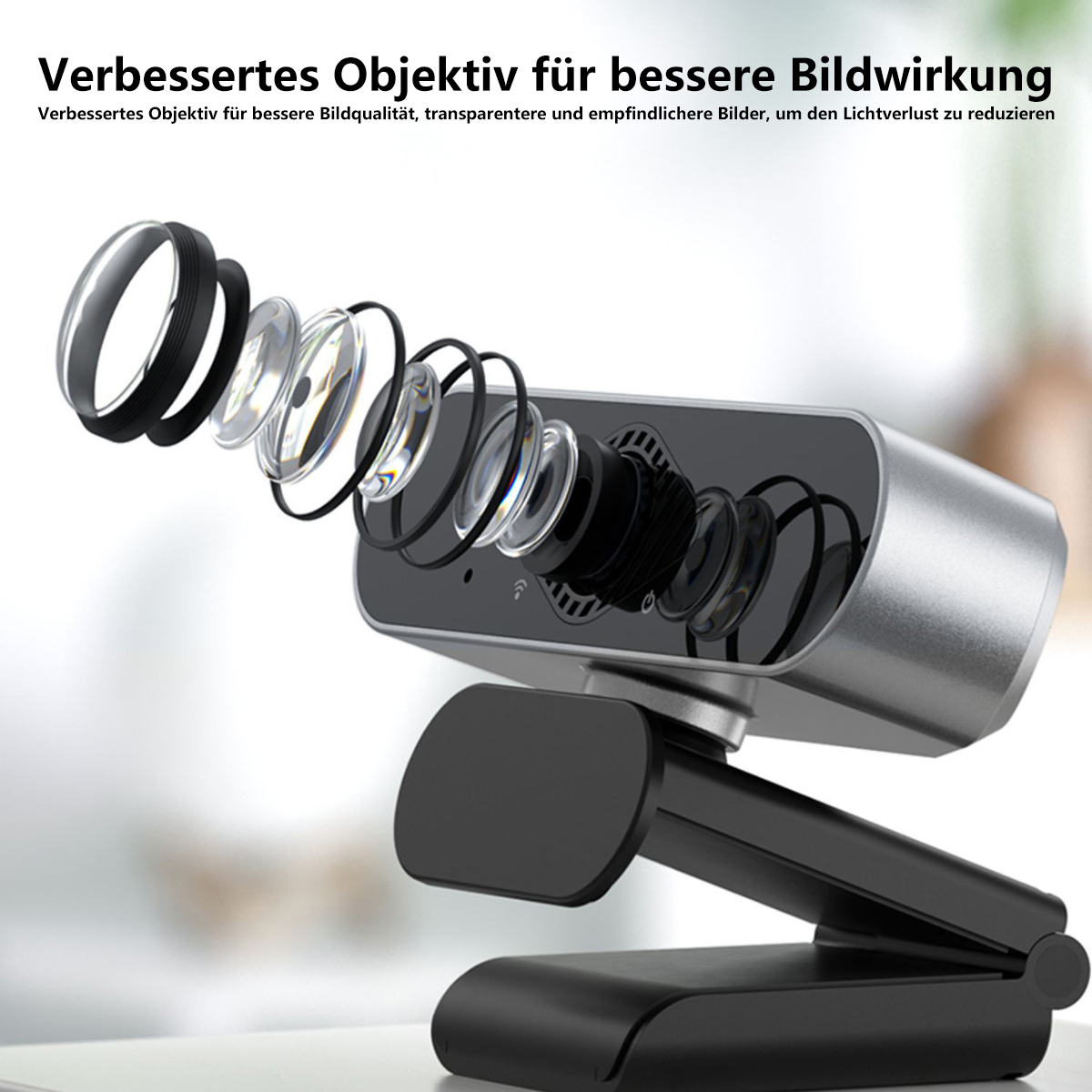 Webcam plateada y negra que muestra los componentes internos de la lente. El texto superior dice 'Verbessertes Objektiv'.