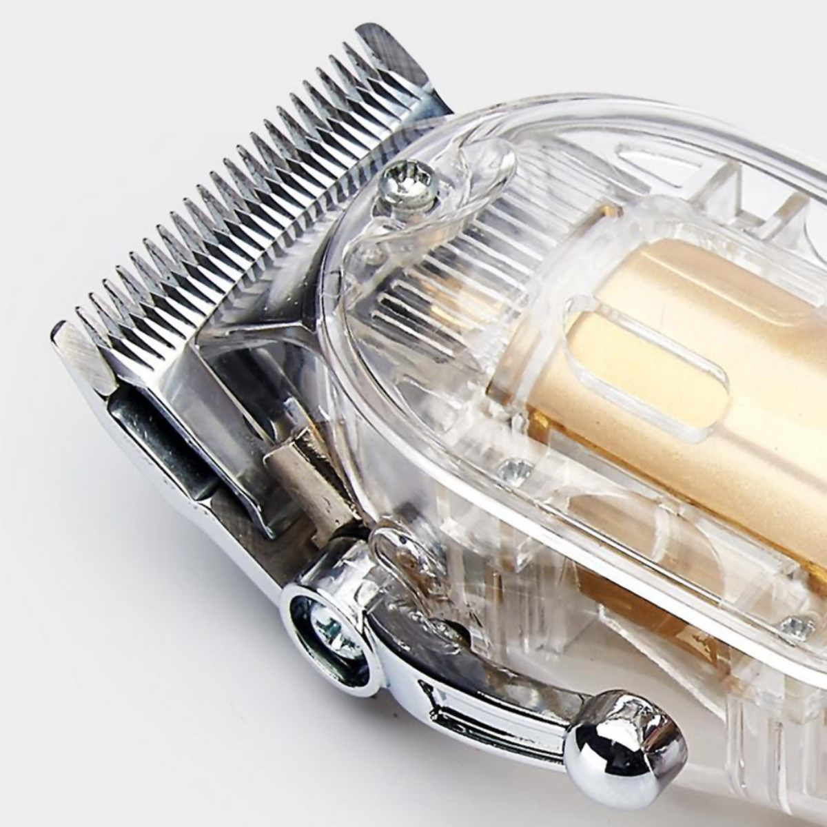 Cortadora de pelo eléctrica transparente con cuchillas plateadas y motor dorado.