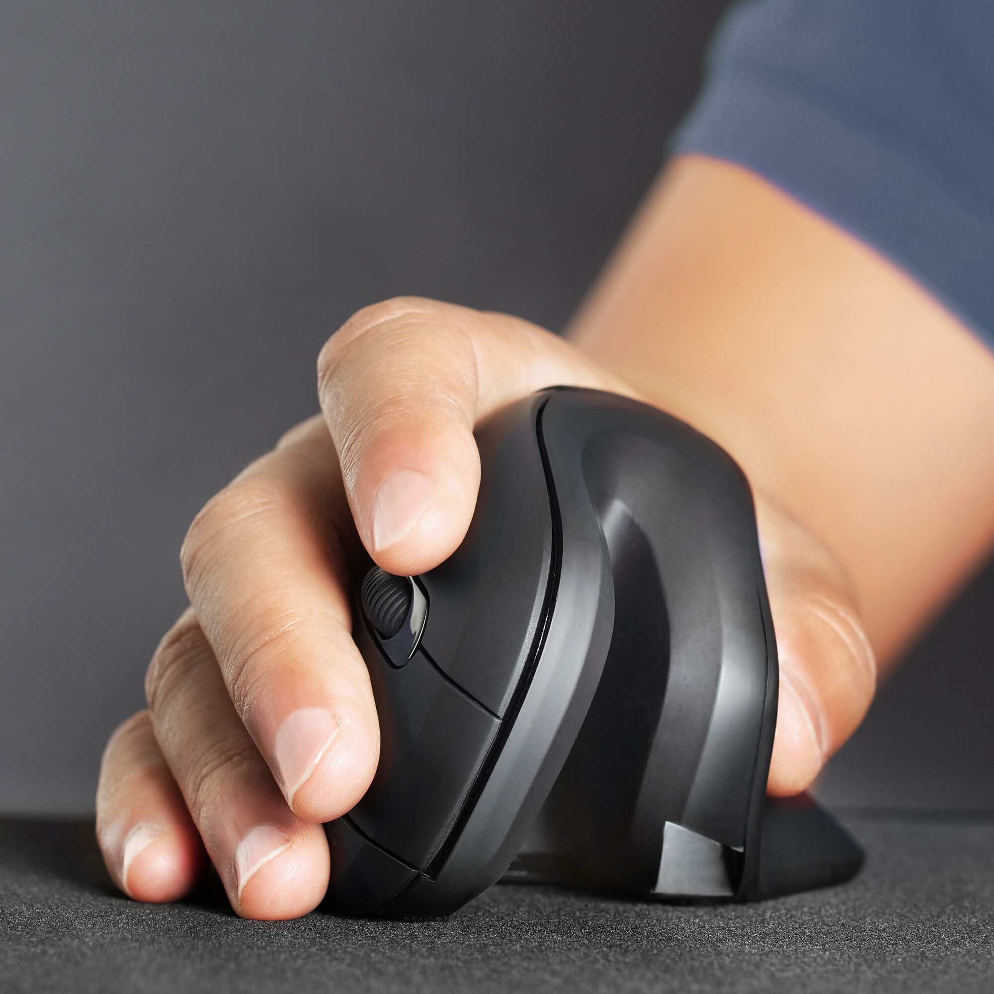 Una mano che tiene un mouse ergonomico nero verticale, con una piccola rotella.