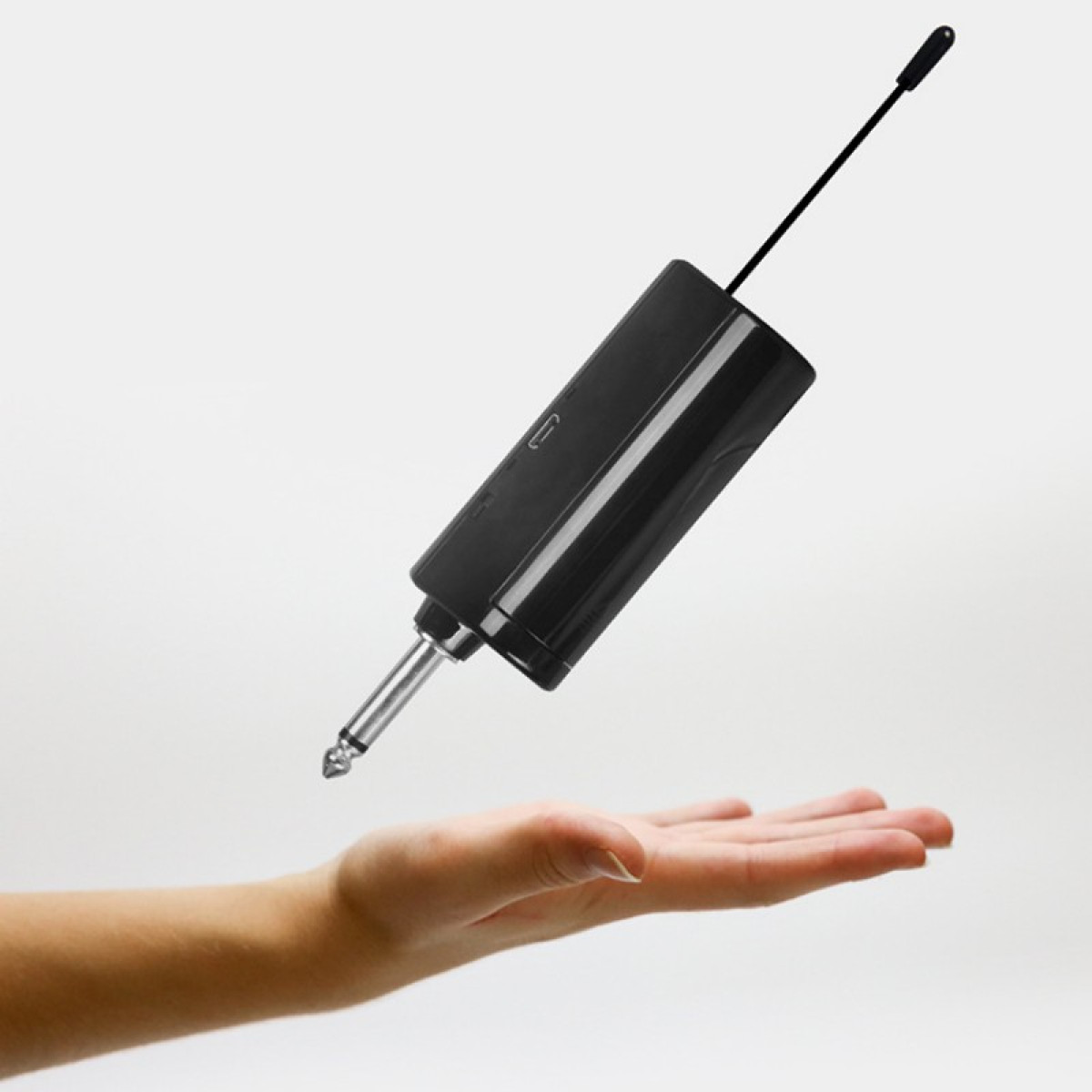 Mikrofon bezprzewodowy z czarnym korpusem i dłonią.