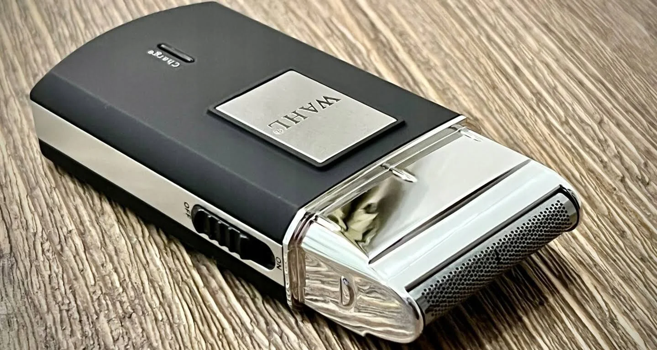 Czarna i srebrna golarka Wahl na drewnianej powierzchni.