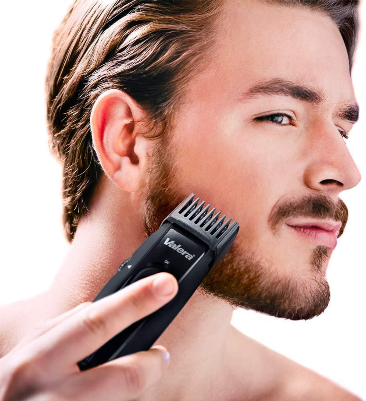 Mężczyzna goli brodę elektryczną maszynką do brody.
