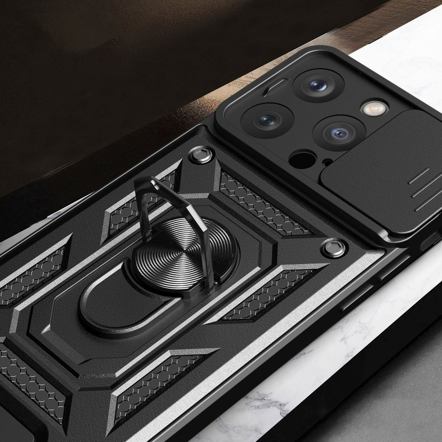 Schwarze Handyhülle mit Ringhalter und Kameraschieber. Strukturiertes Design, auf weißer Oberfläche platziert.
