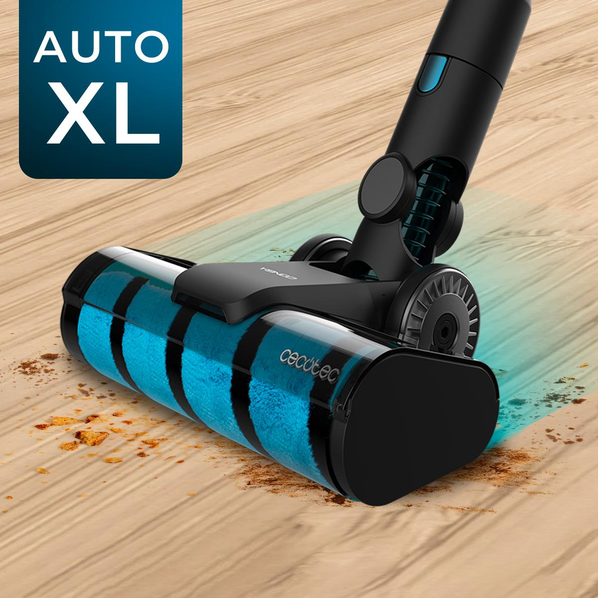 Cabezal de aspiradora negro y azul sobre suelo de madera, con texto AUTO XL. Suciedad delante.