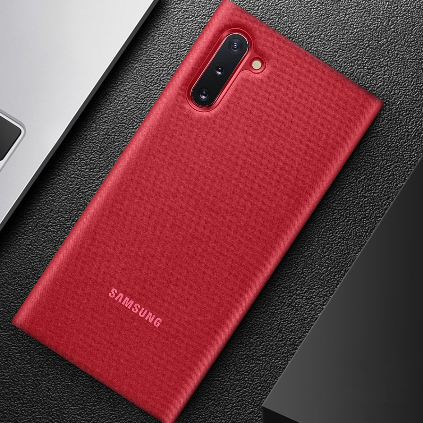 Una funda roja para teléfono sobre una superficie oscura, con el logo de Samsung visible.