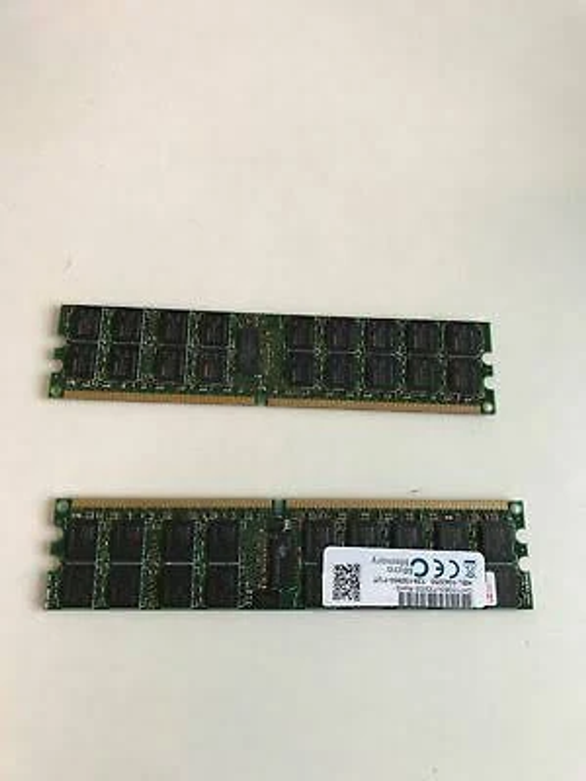 Due moduli RAM su sfondo bianco. I moduli sono verdi e hanno diversi chip.
