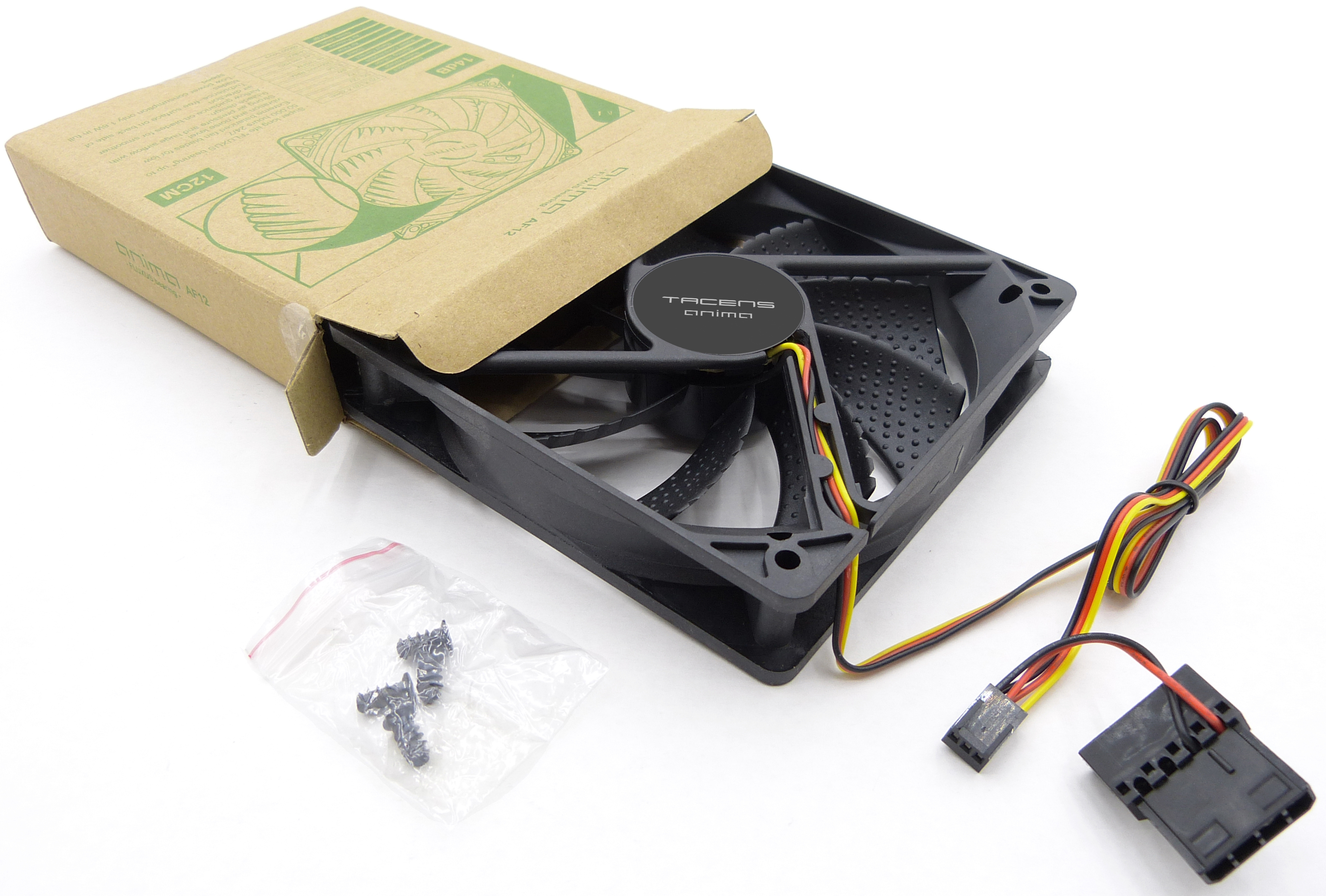 Un ventilador de ordenador negro con caja y accesorios sobre superficie blanca.