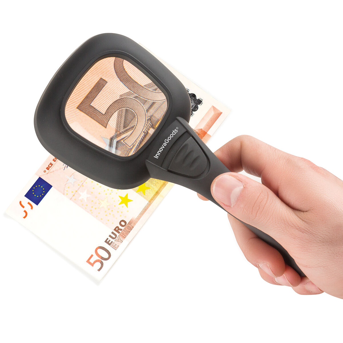 Una mano sosteniendo una lupa sobre un billete de 50 euros.