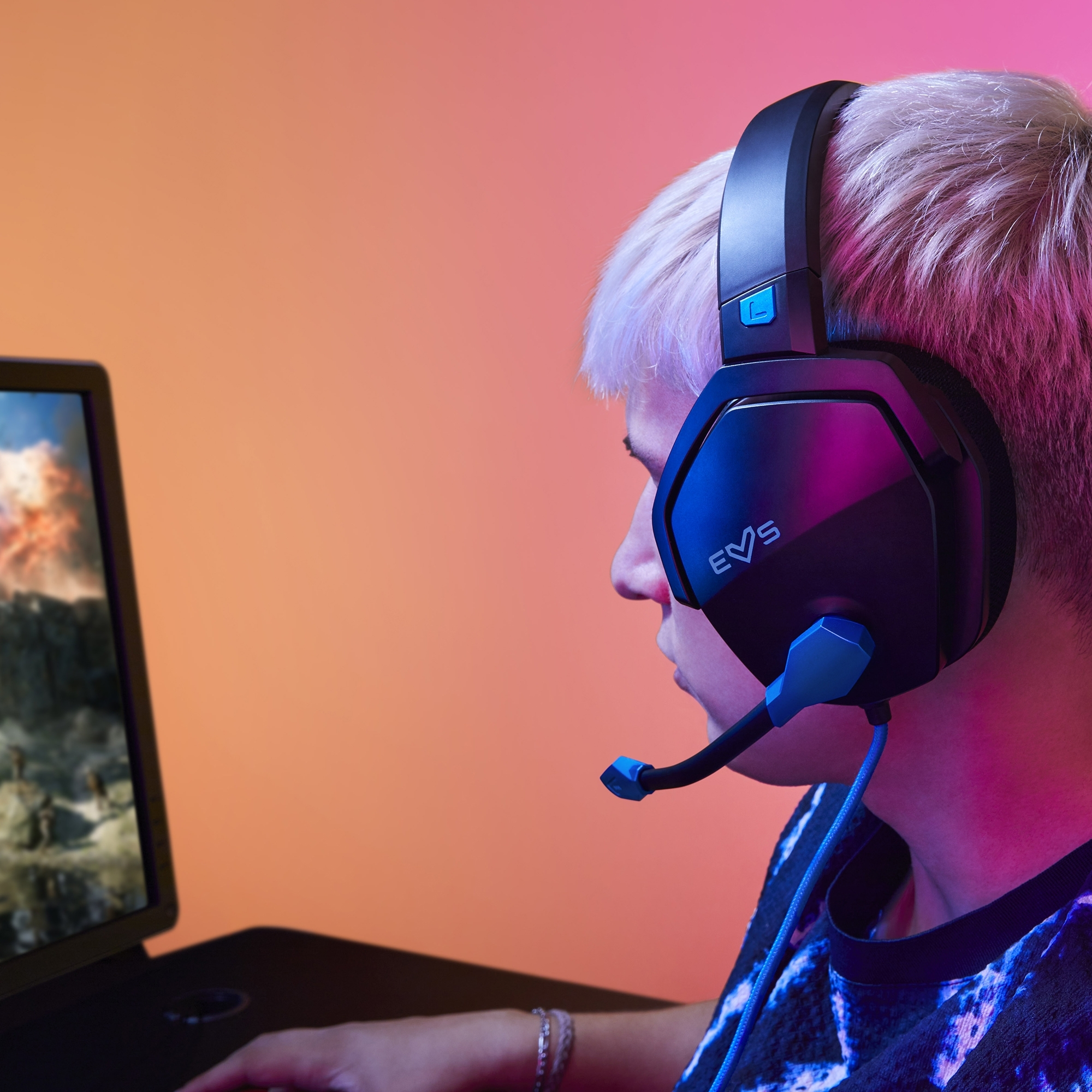 Persona usando auriculares y mirando una pantalla de computadora, configuración de juego.