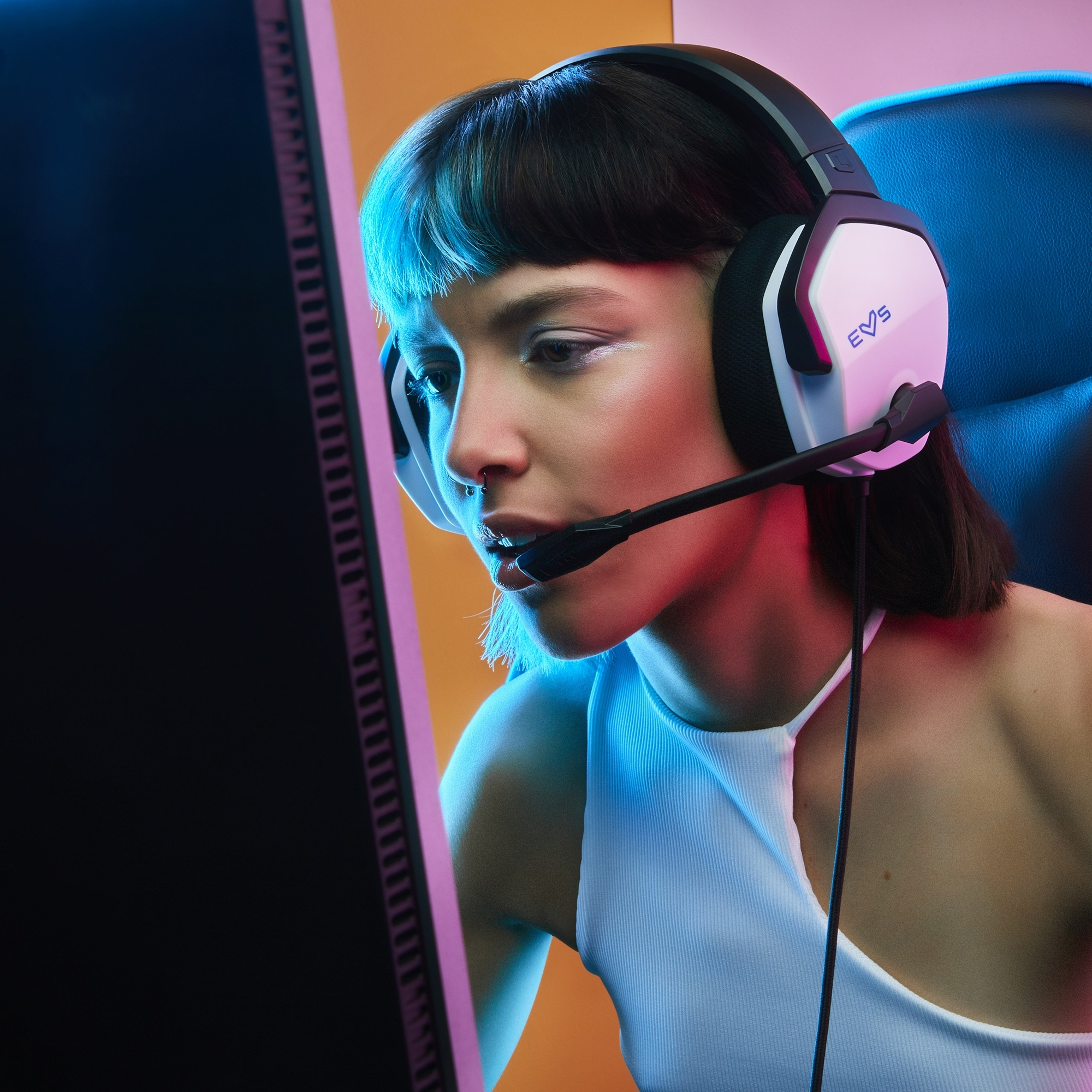 Kobieta gra z zestawem słuchawkowym. Zestaw słuchawkowy jest biały z mikrofonem. Ciemne tło z neonami.