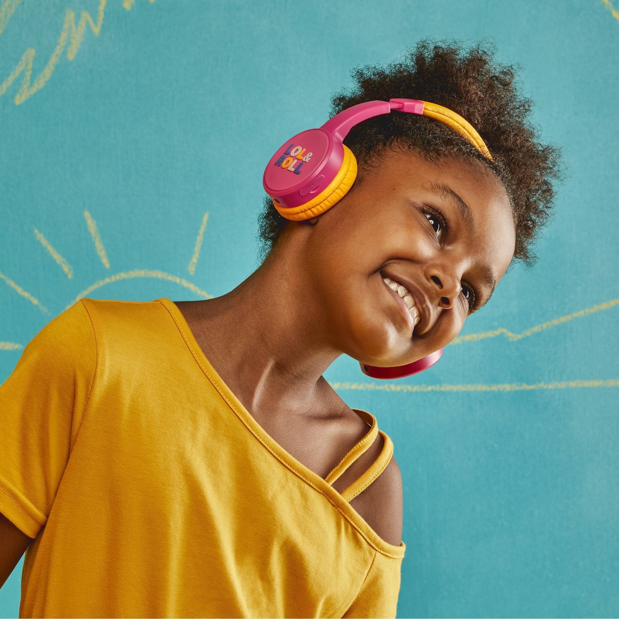 Joven niña con auriculares rosas y amarillos.
