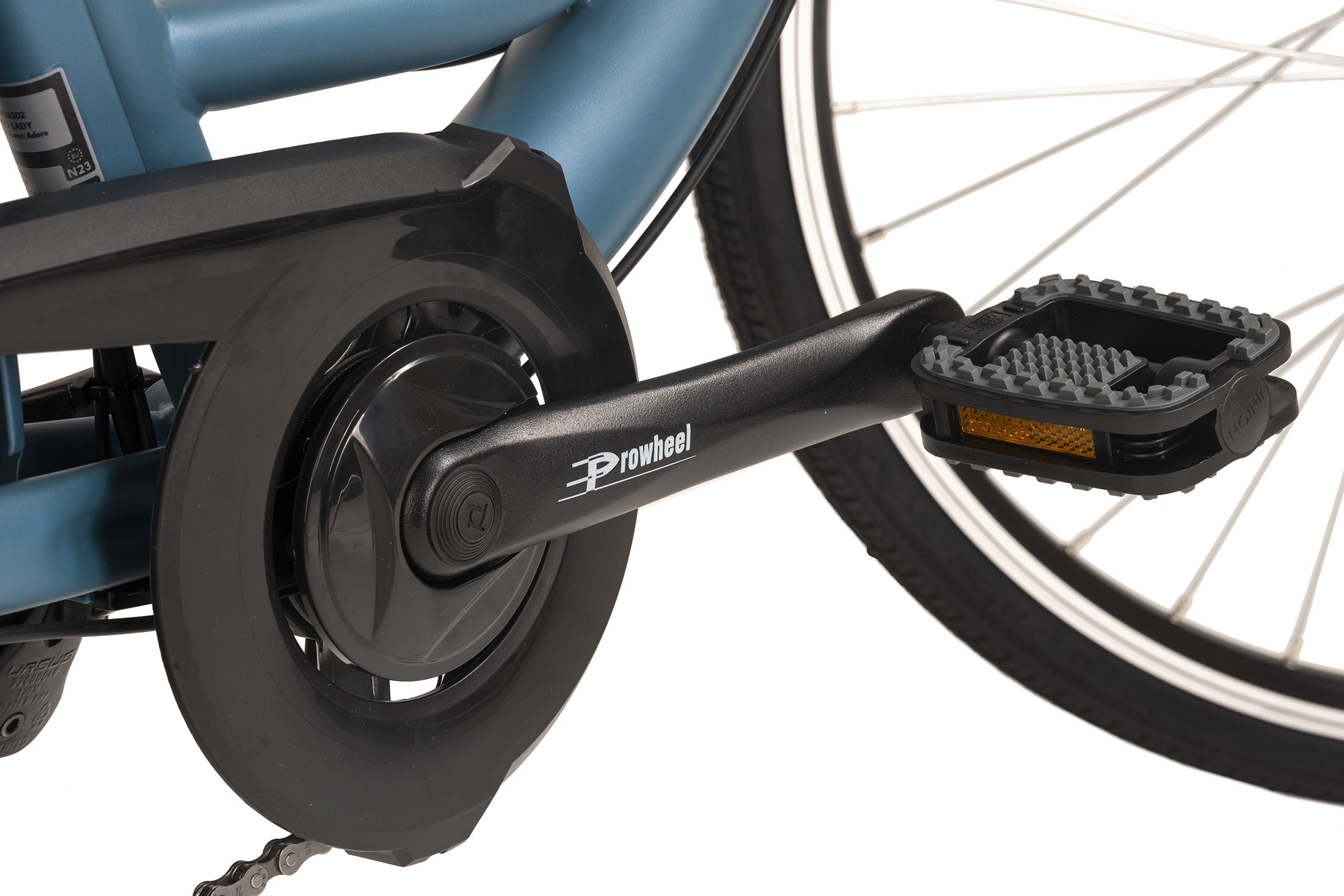 Nahaufnahme eines Fahrradpedals und Kettenschutzes. Das Pedal ist schwarz mit Reflexstreifen.