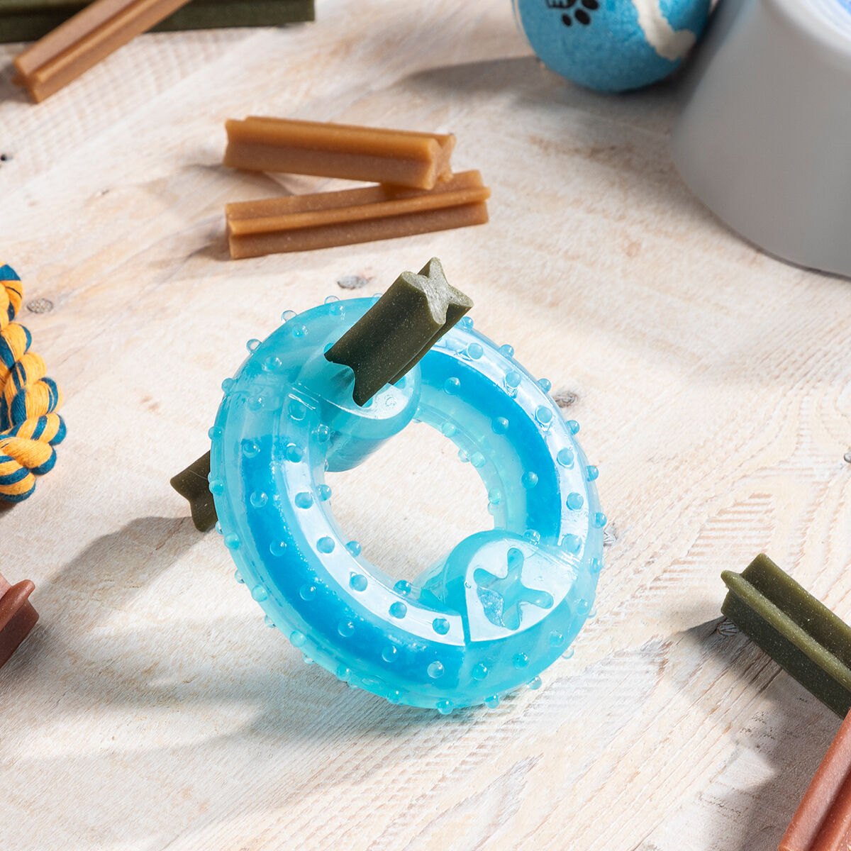 Anillo de juguete azul para perros con insertos verdes y palitos marrones.