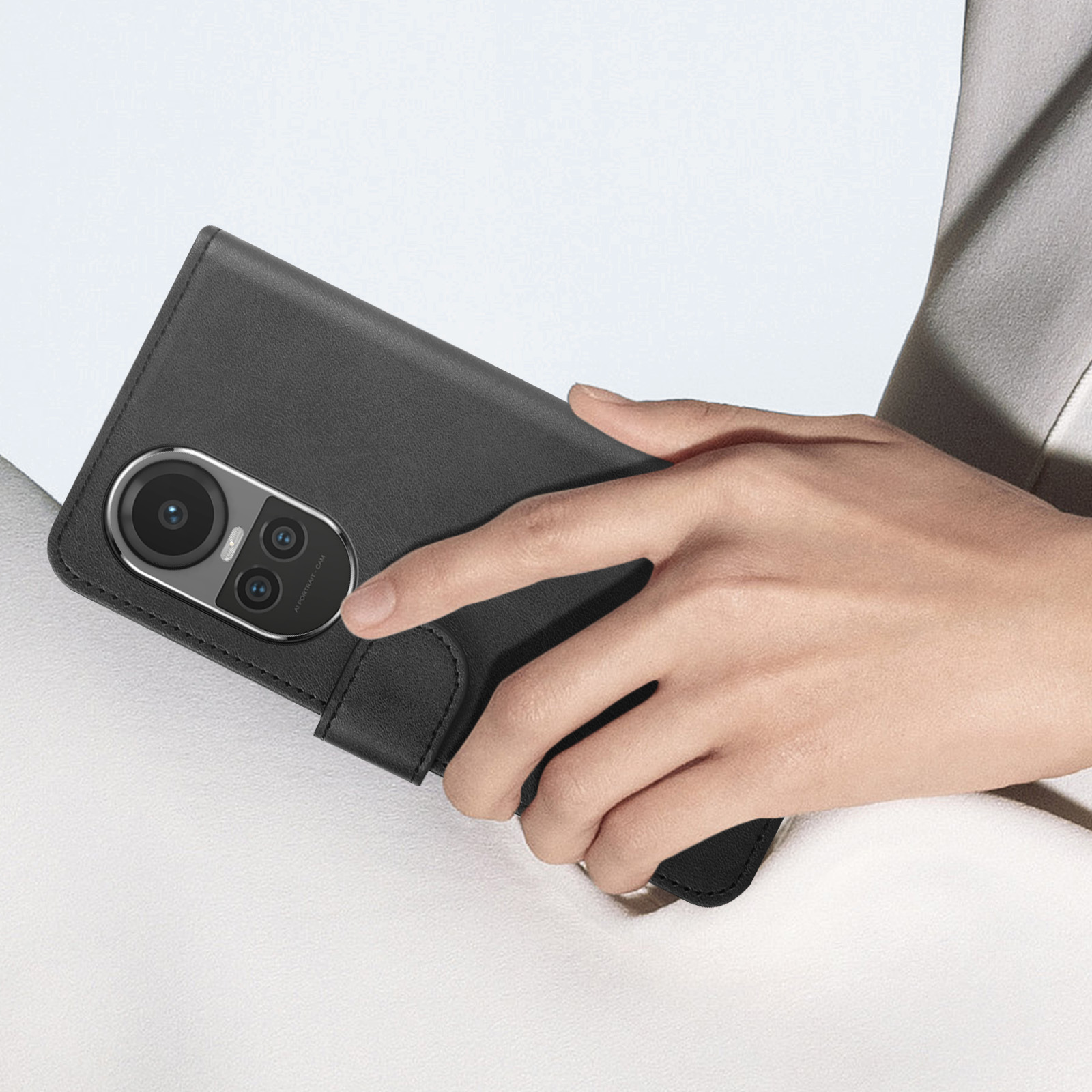 Hand hält eine schwarze Handyhülle. Die Hülle hält ein Telefon und hat einen Kameraausschnitt.