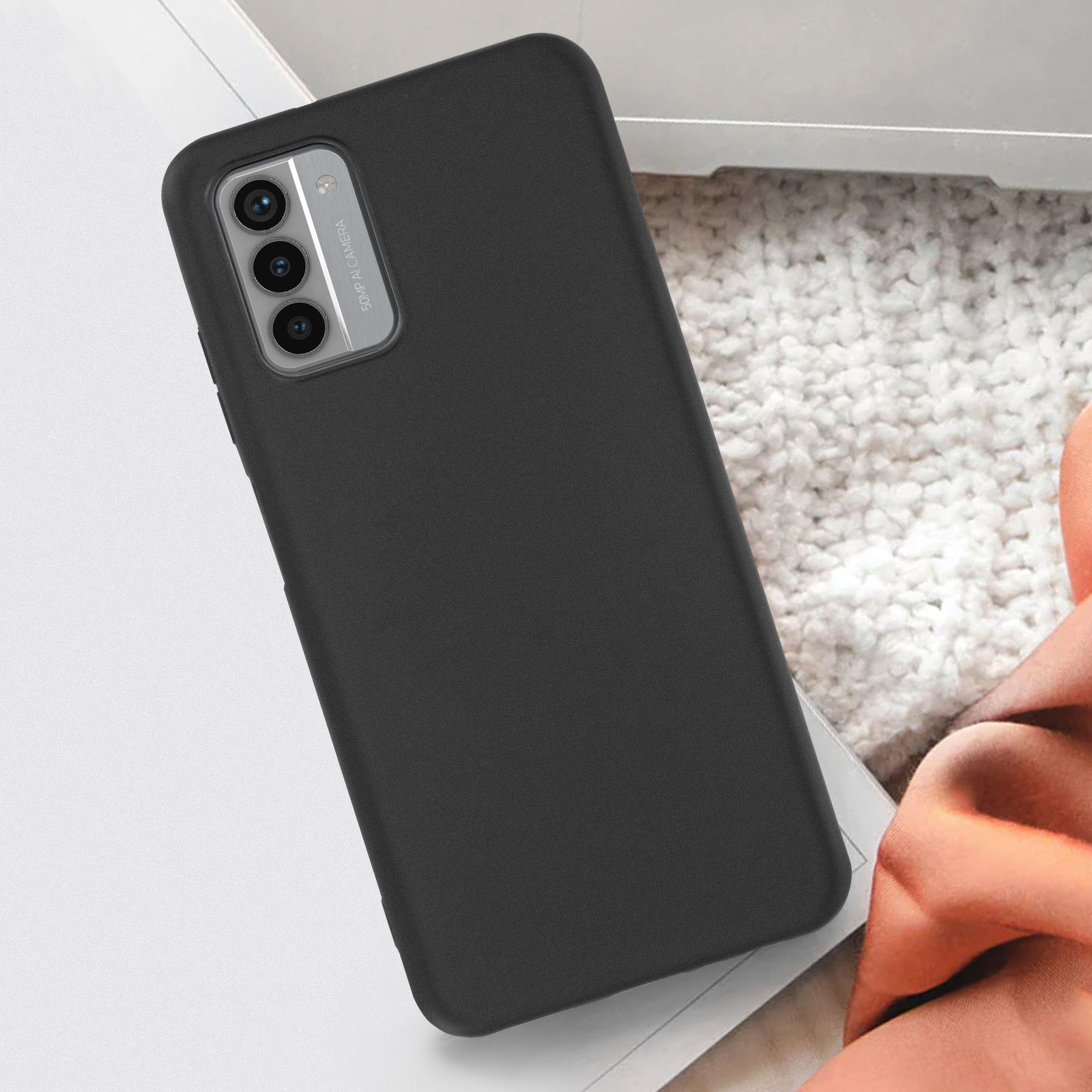 Custodia nera per telefono con sezione fotocamera, su superficie morbida.