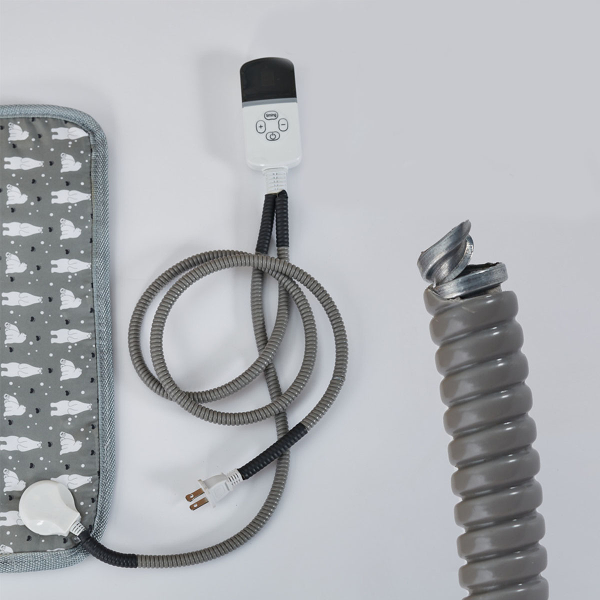 Heizkissen mit Steuerung, grauem Kabel und abgetrenntem, grauem Wellrohr.